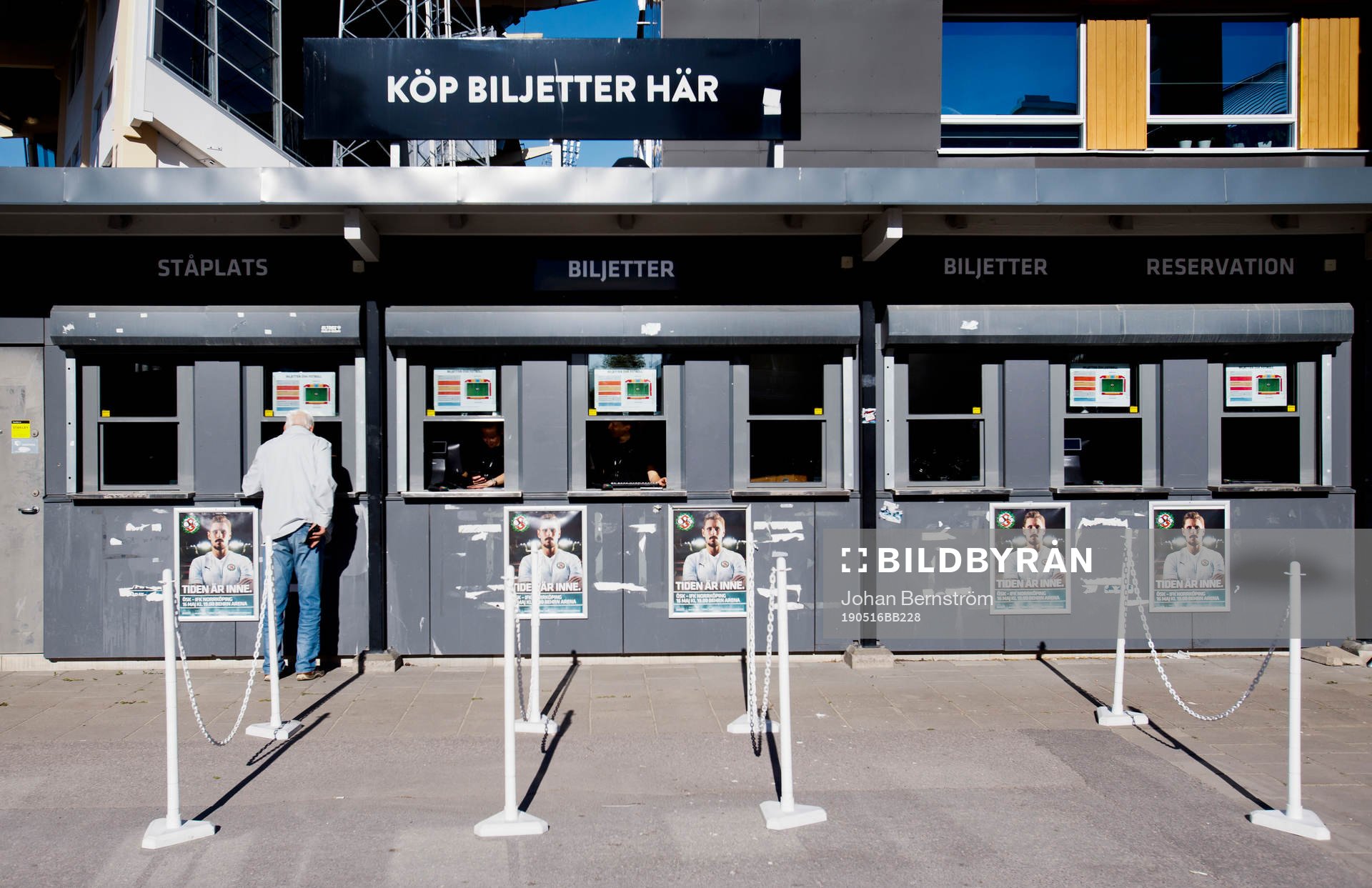 En person köper biljetter i biljettkassan