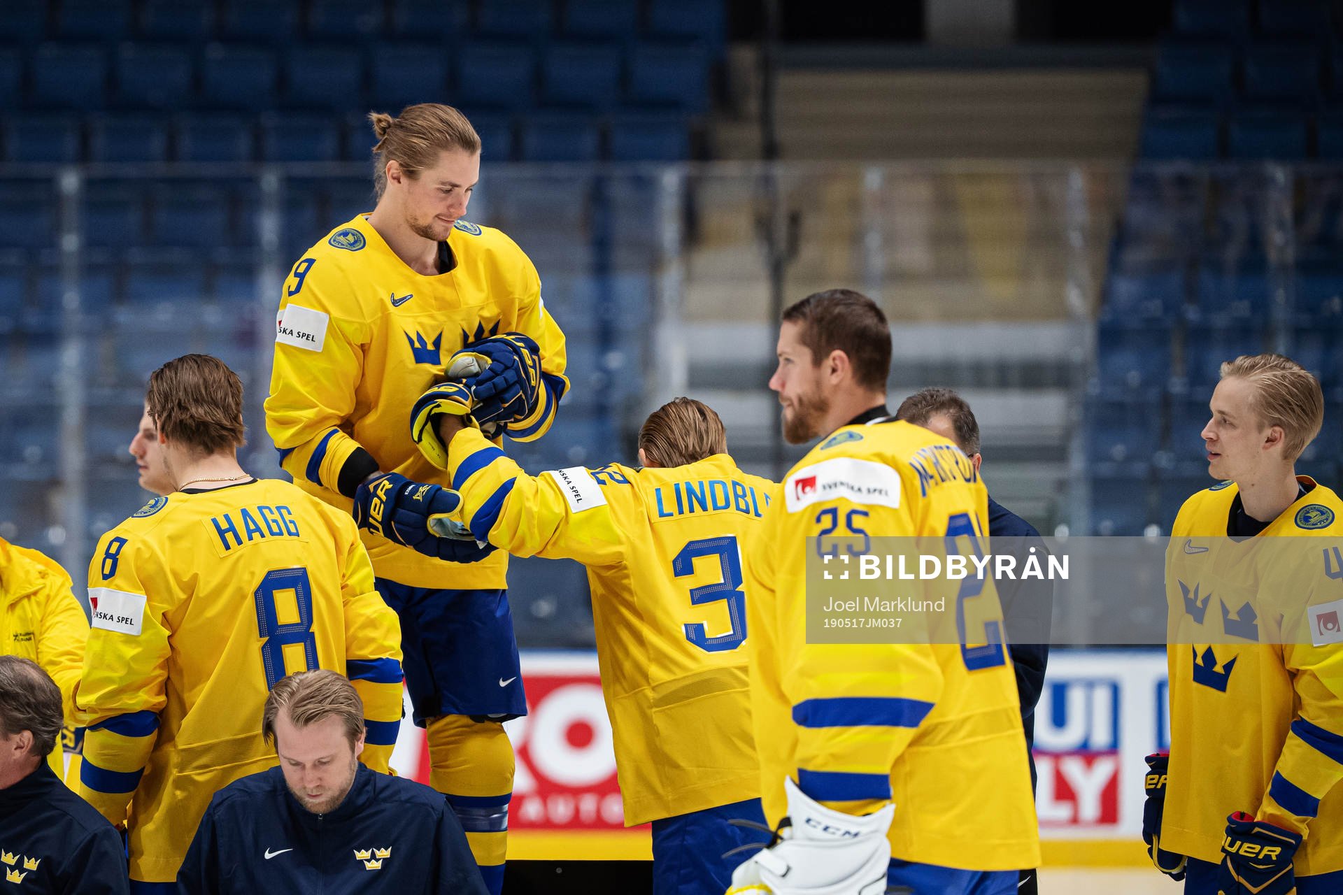 Adrian Kempe helps Oskar Lindblom of Sweden at a photo shoot