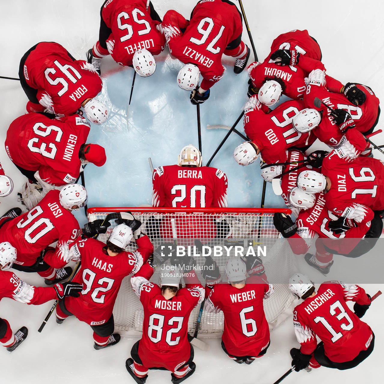 Players of Switzerland gather around goaltender Reto Berra