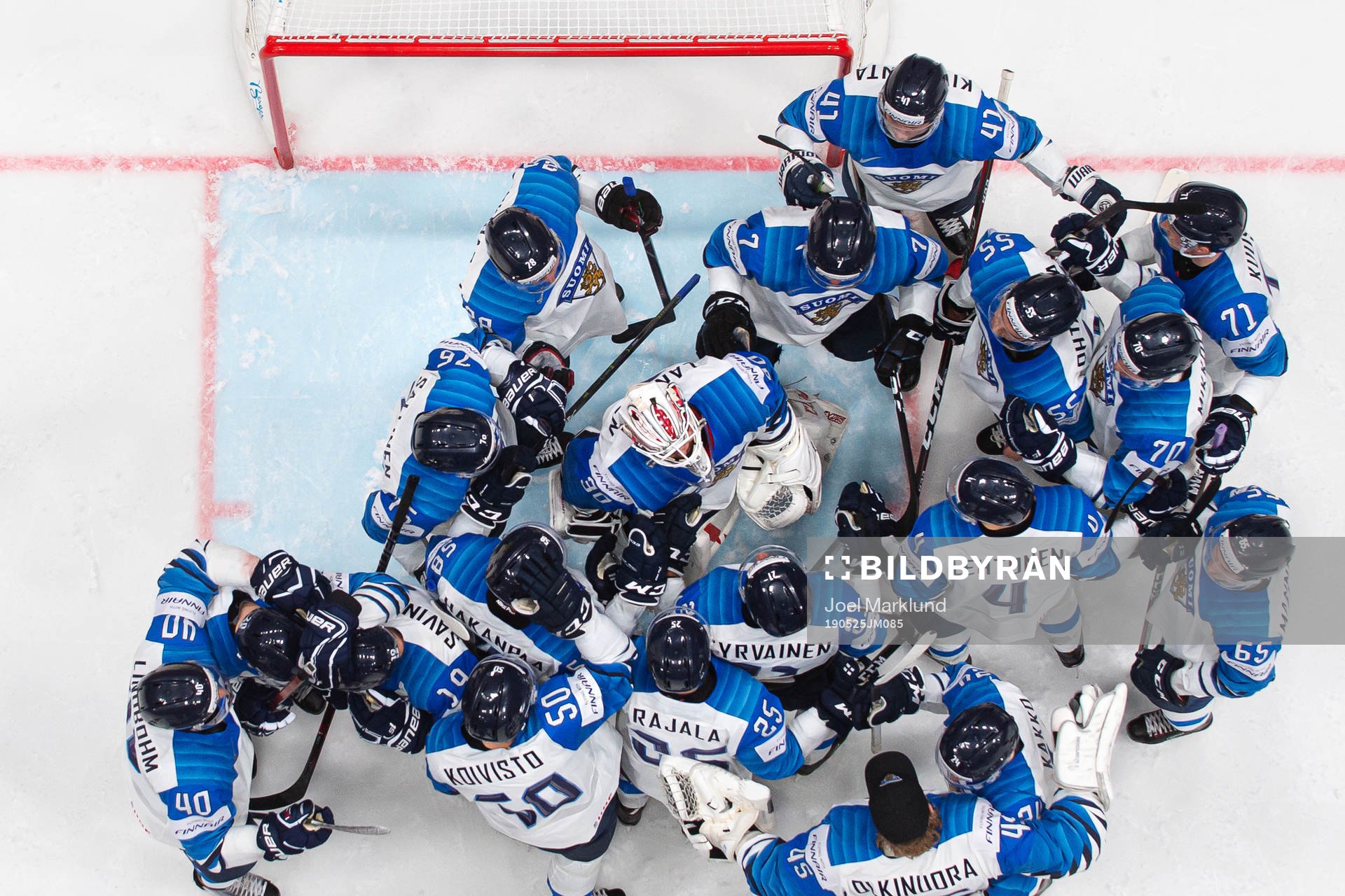 Players of Finland gather around goaltender Kevin Lankinen