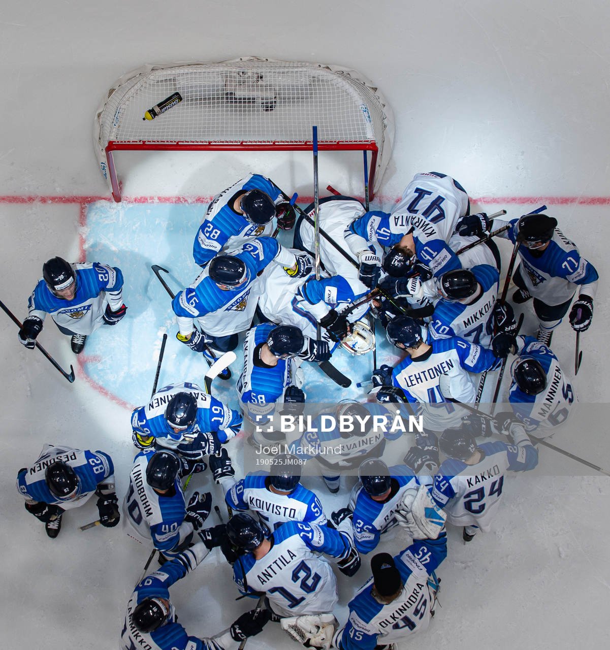 Players of Finland gather around goaltender Kevin Lankinen