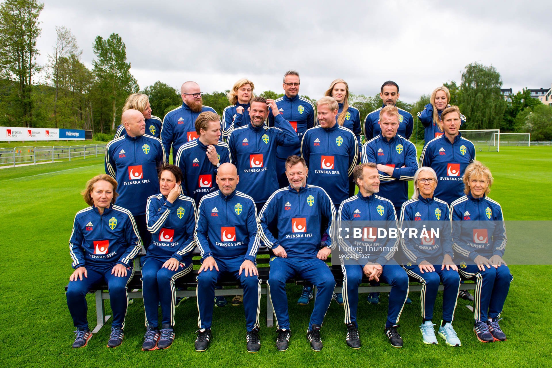 Staff prepare for a team photo shoot with coaching staff of