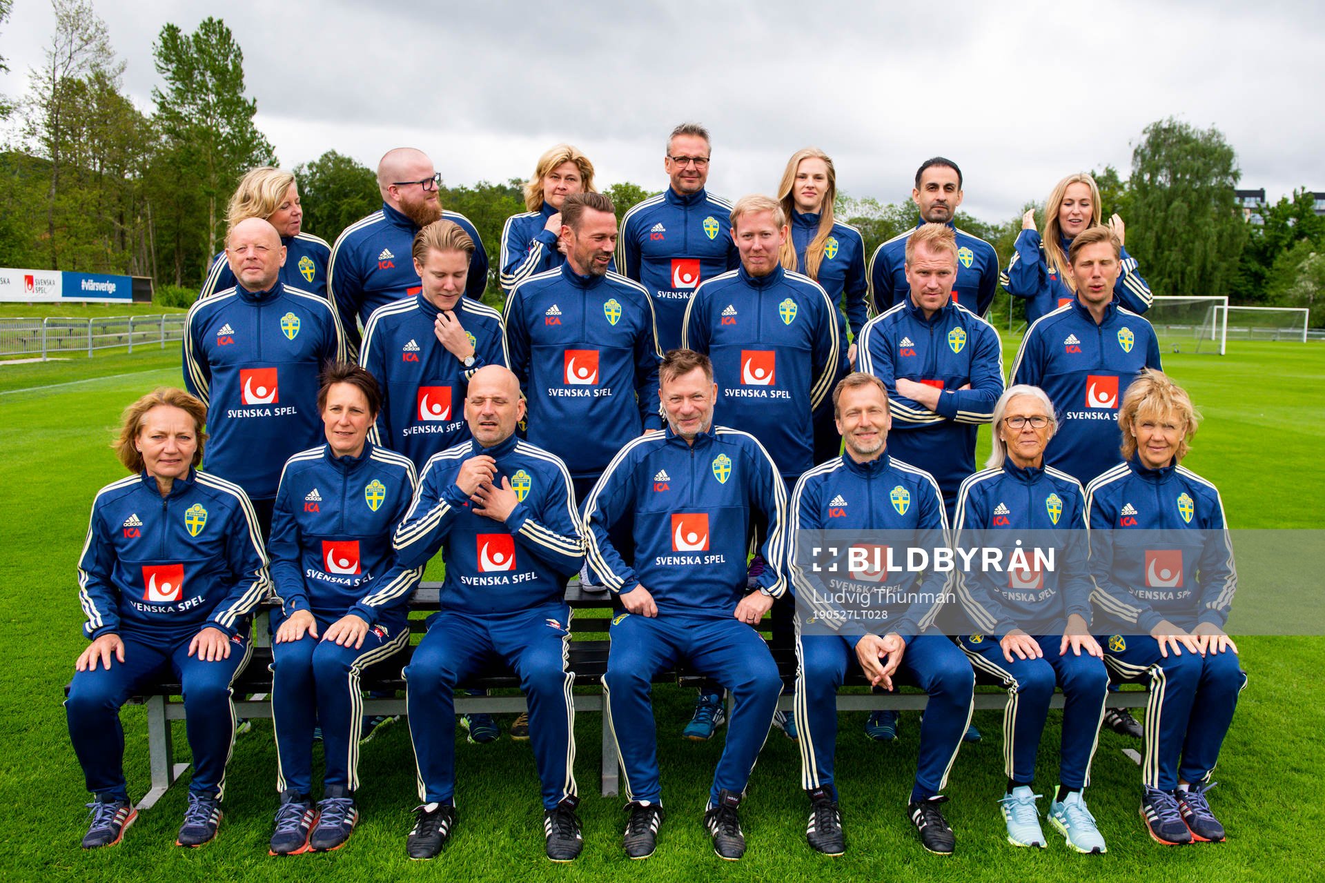 Staff prepare for a team photo shoot with coaching staff of