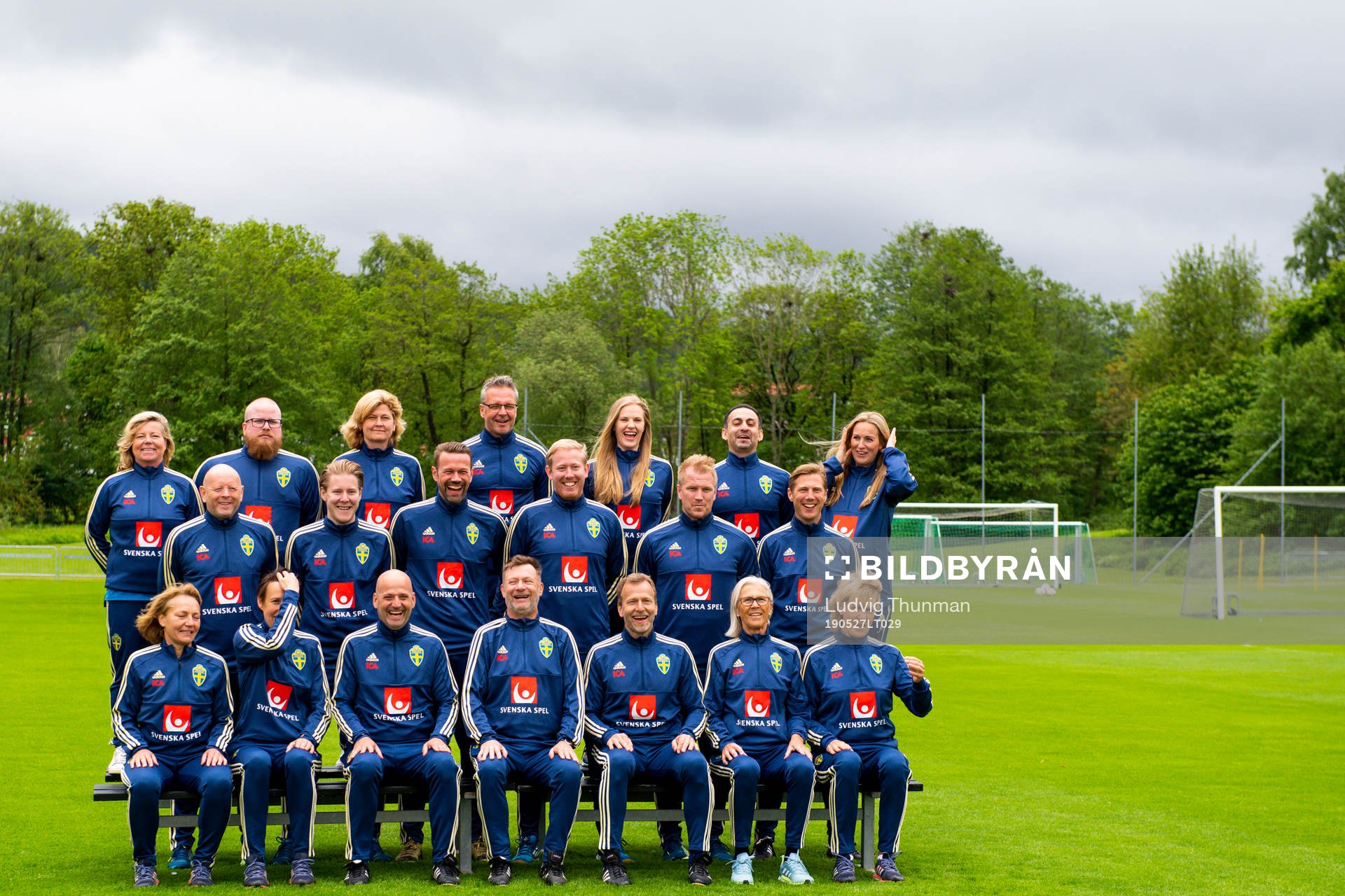 Staff prepare for a team photo shoot with coaching staff of