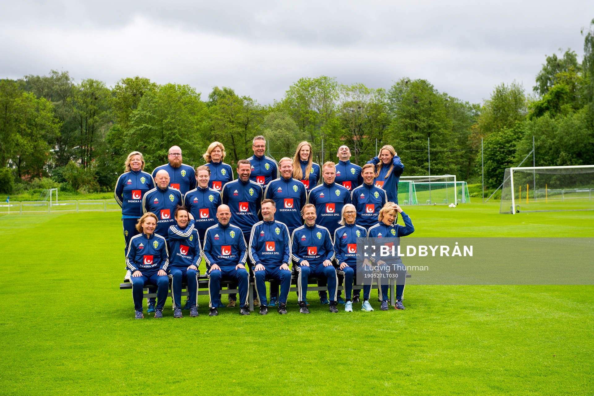 Staff prepare for a team photo shoot with coaching staff of