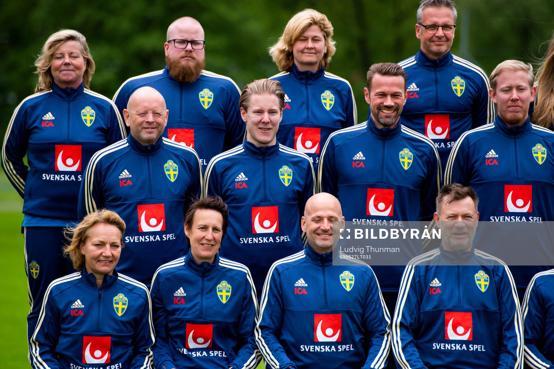 Staff prepare for a team photo shoot with coaching staff of