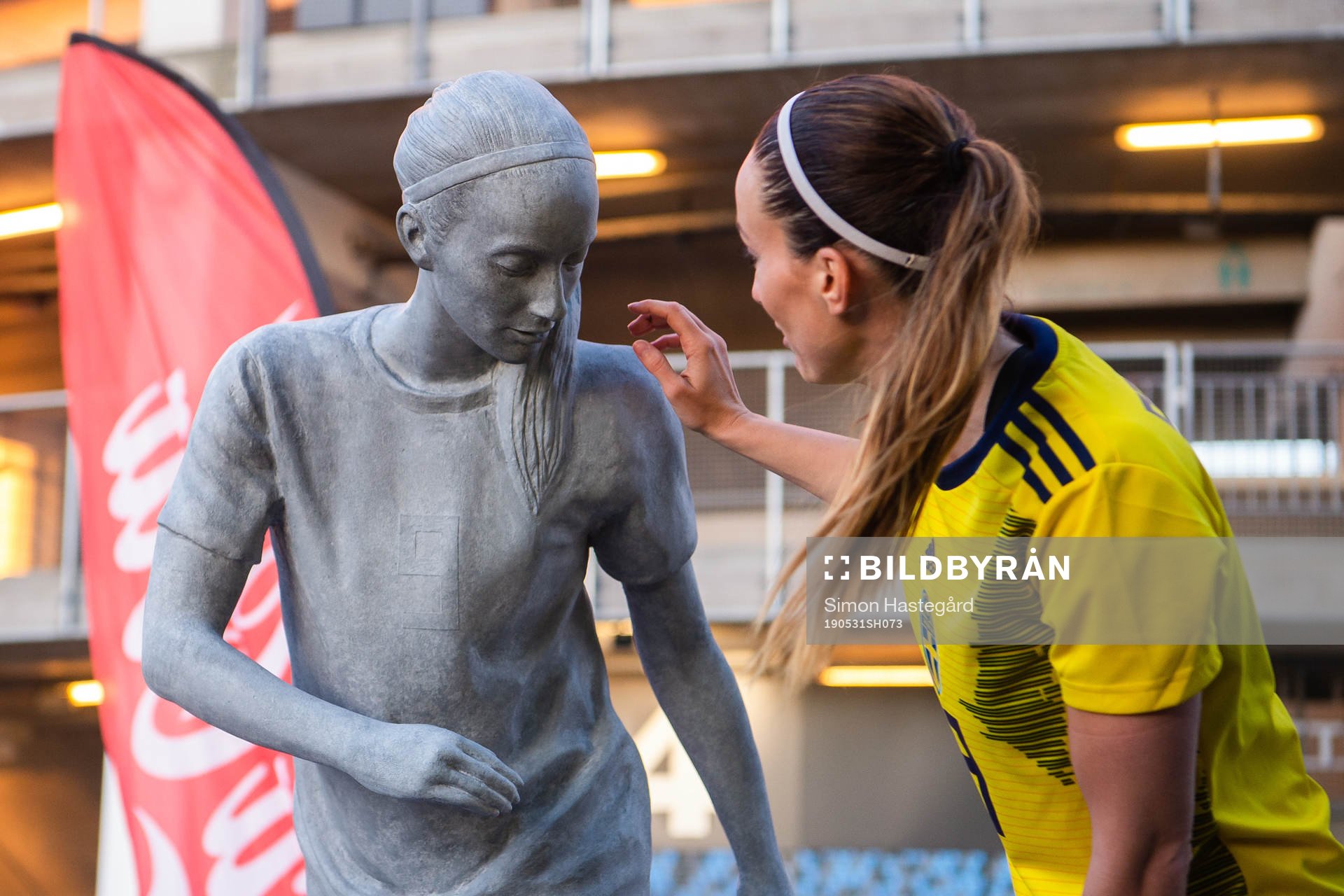 Kosovare Asllani of Sweden next to a statue of herself