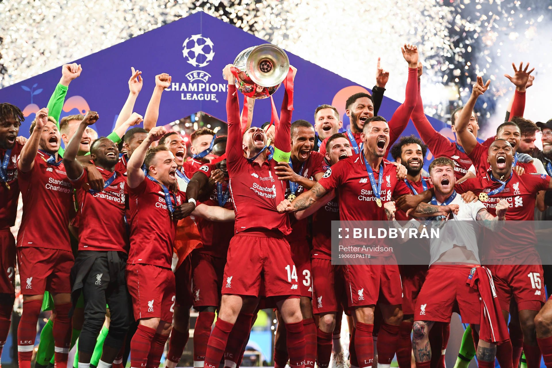 Jordan Henderson of Liverpool raises the throphy in front