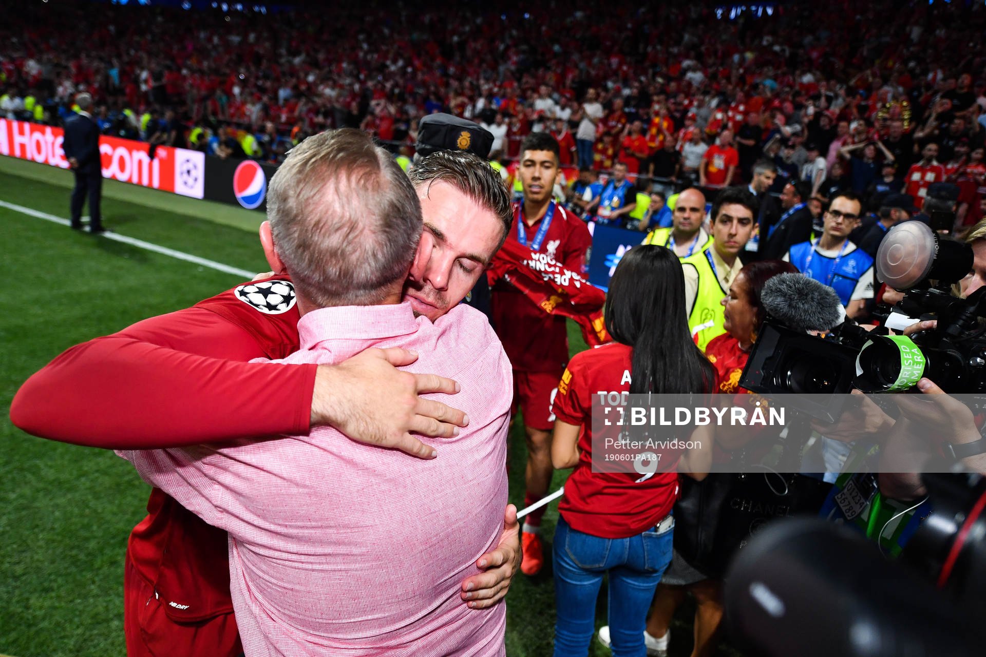 Jordan Henderson of Liverpool hugs a man as he celebrate