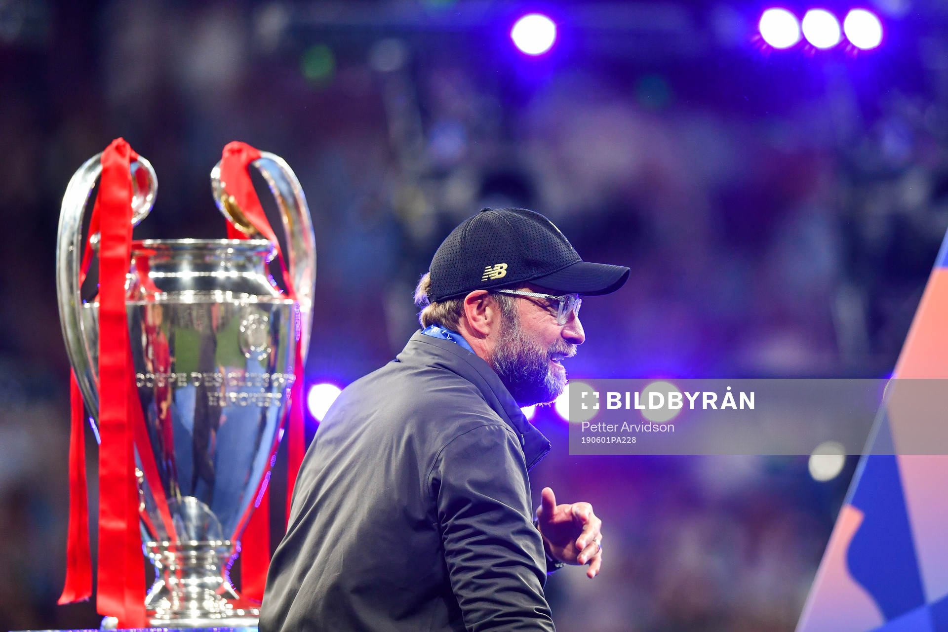 Head coach Jürgen Klopp of Liverpool walks by the trophy