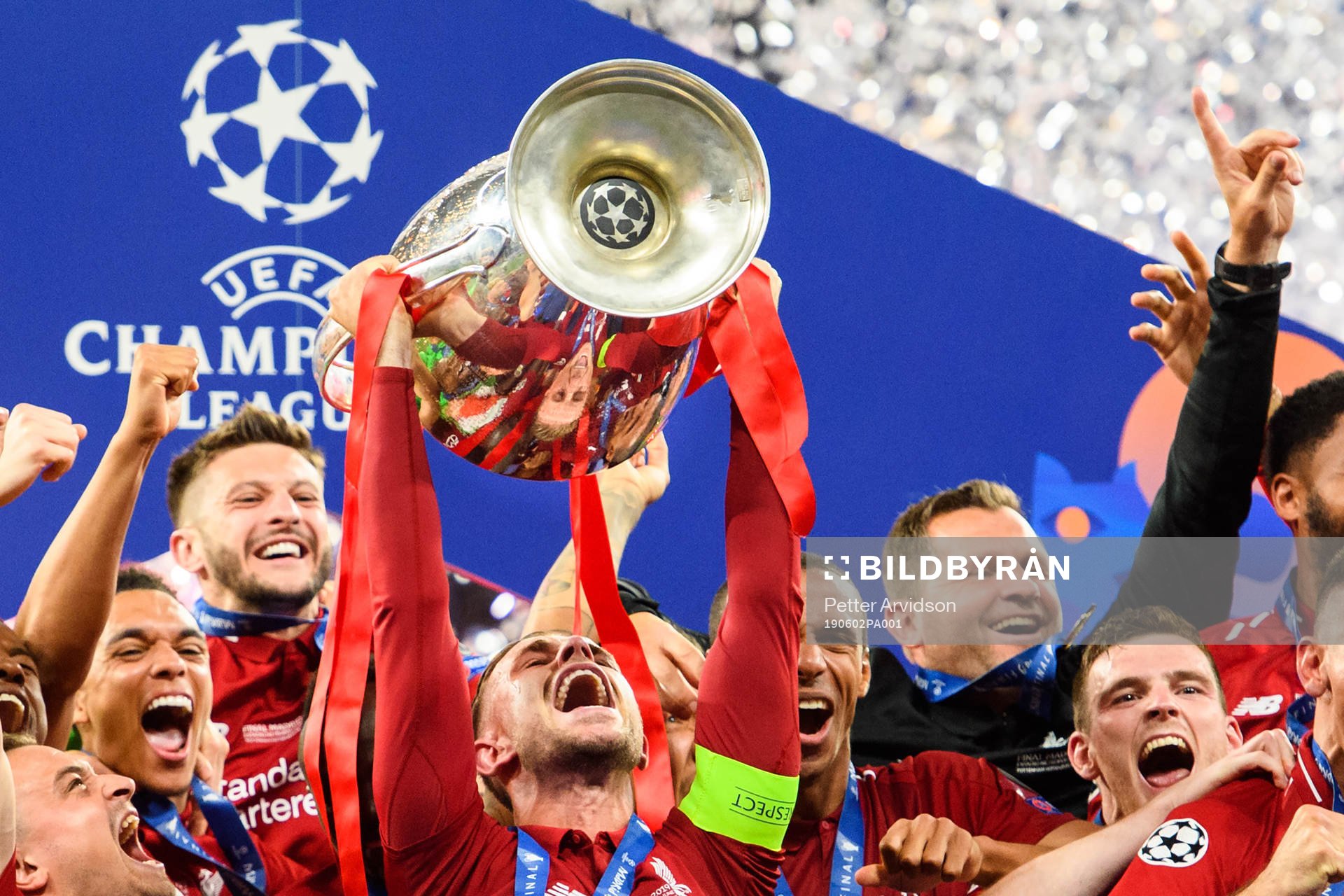 Jordan Henderson of Liverpool raises the throphy in front
