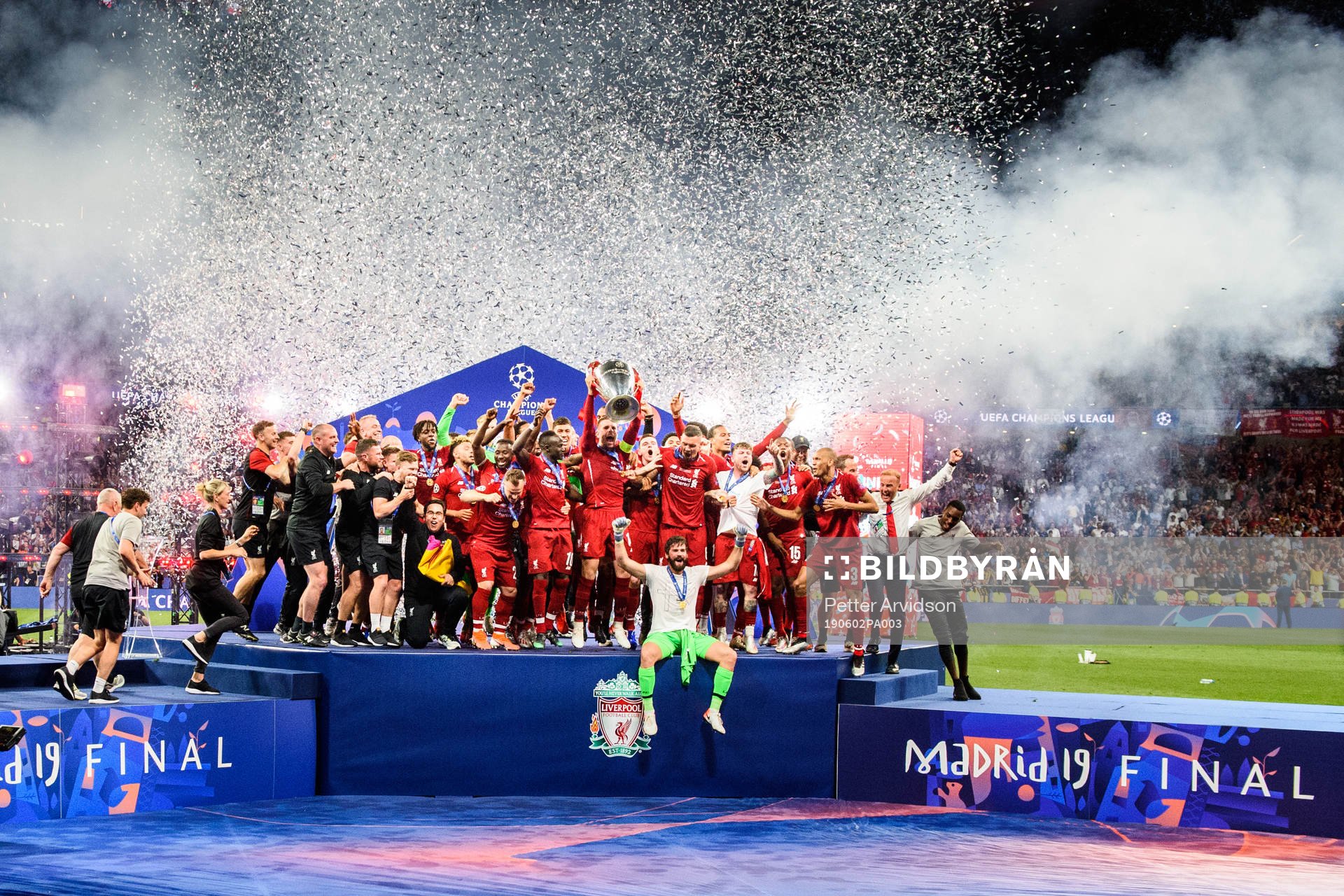 Jordan Henderson of Liverpool raises the throphy in front