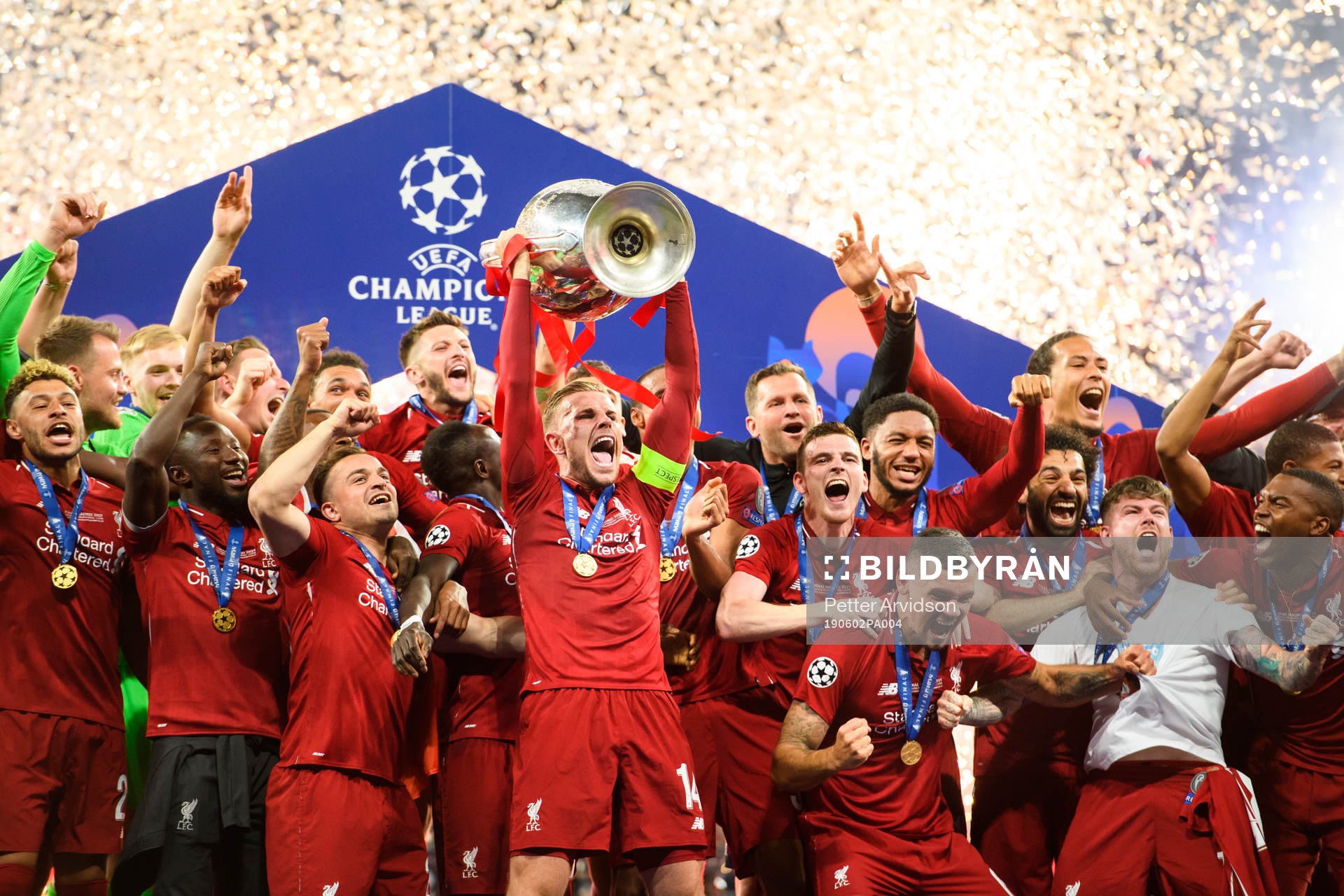 Jordan Henderson of Liverpool raises the throphy in front