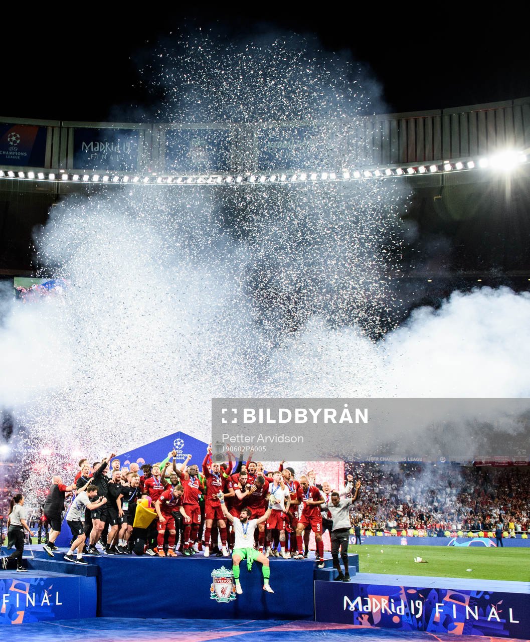 Jordan Henderson of Liverpool raises the throphy in front
