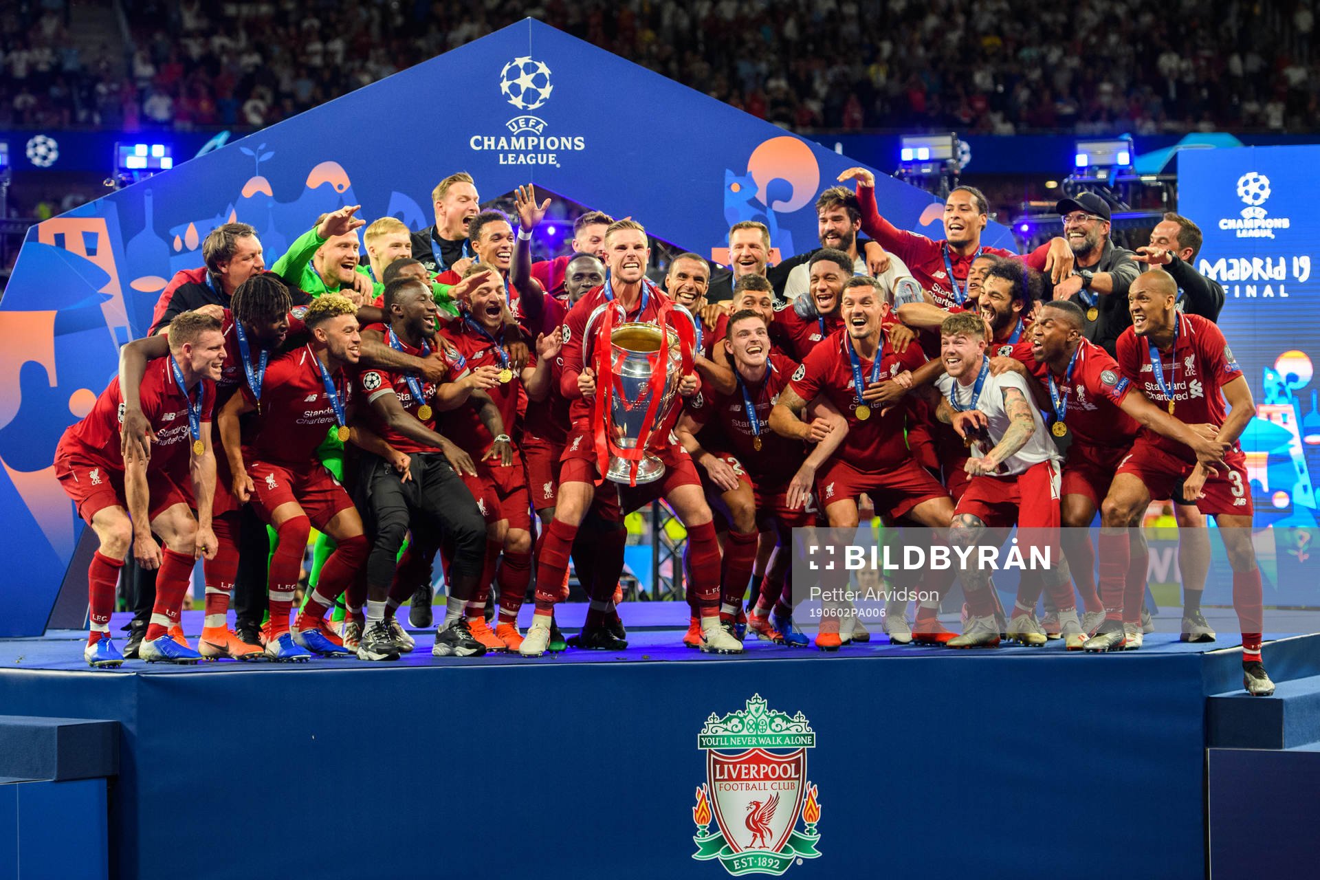 Jordan Henderson of Liverpool raises the throphy in front