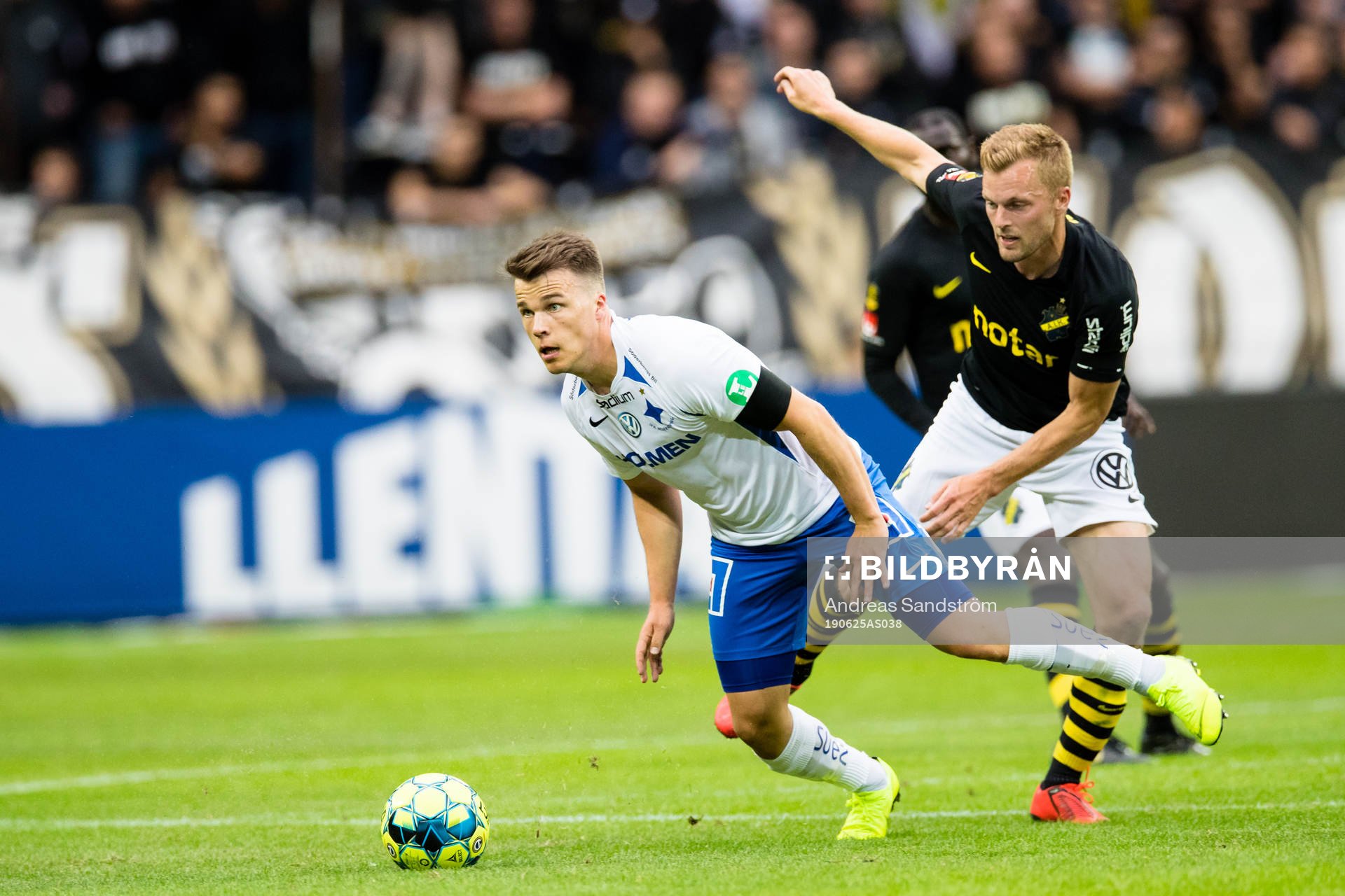 IFK Norrköpings Simon Skrabb i kamp om bollen med AIK:s Sebastian Larsson under fotbollsmatchen i Allsvenskan mellan AIK och IFK Norrköping den 25 juni 2019 i Stockholm.
