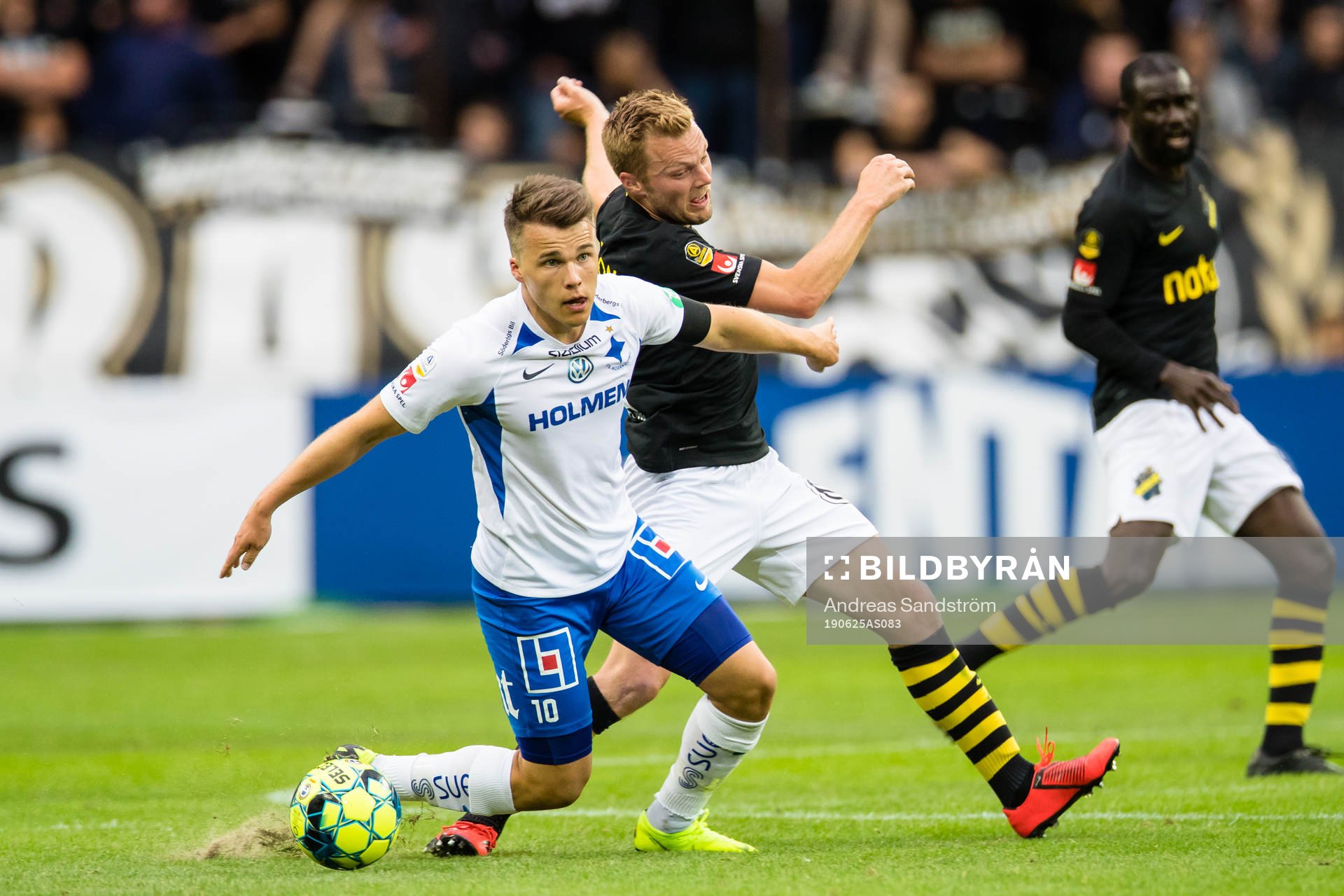 IFK Norrköpings Simon Skrabb i kamp om bollen med AIK:s Sebastian Larsson under fotbollsmatchen i Allsvenskan mellan AIK och IFK Norrköping den 25 juni 2019 i Stockholm.