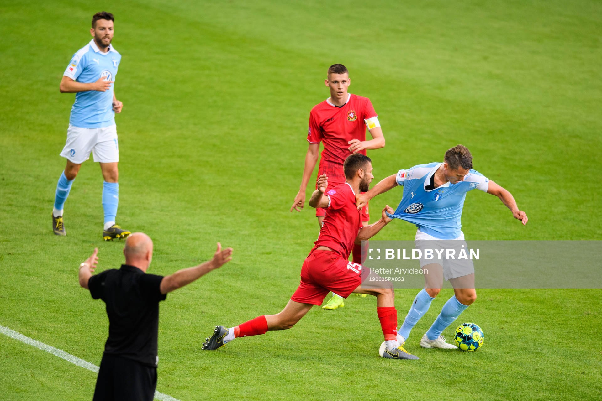 Malmö FFs Markus Rosenberg hålls fast i närkamp med Goricas Nemanja Ljubisavljevic och Malmö FFs tränare Uwe Rösler reagerar under träningsmatchen i fotboll mellan Malmö FF och Gorica den 25 juni 2019 i Malmö.