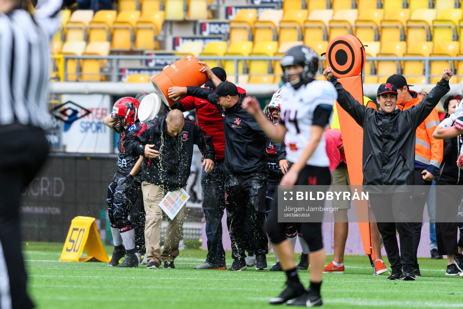 Carlstad Crusaders head coach Christian Forsman får dricka över sig under damernas SM-final i amerikansk fotboll mellan Carlstad Crusaders och Örebro Black Knights den 6 Juli 2019 i Borås.