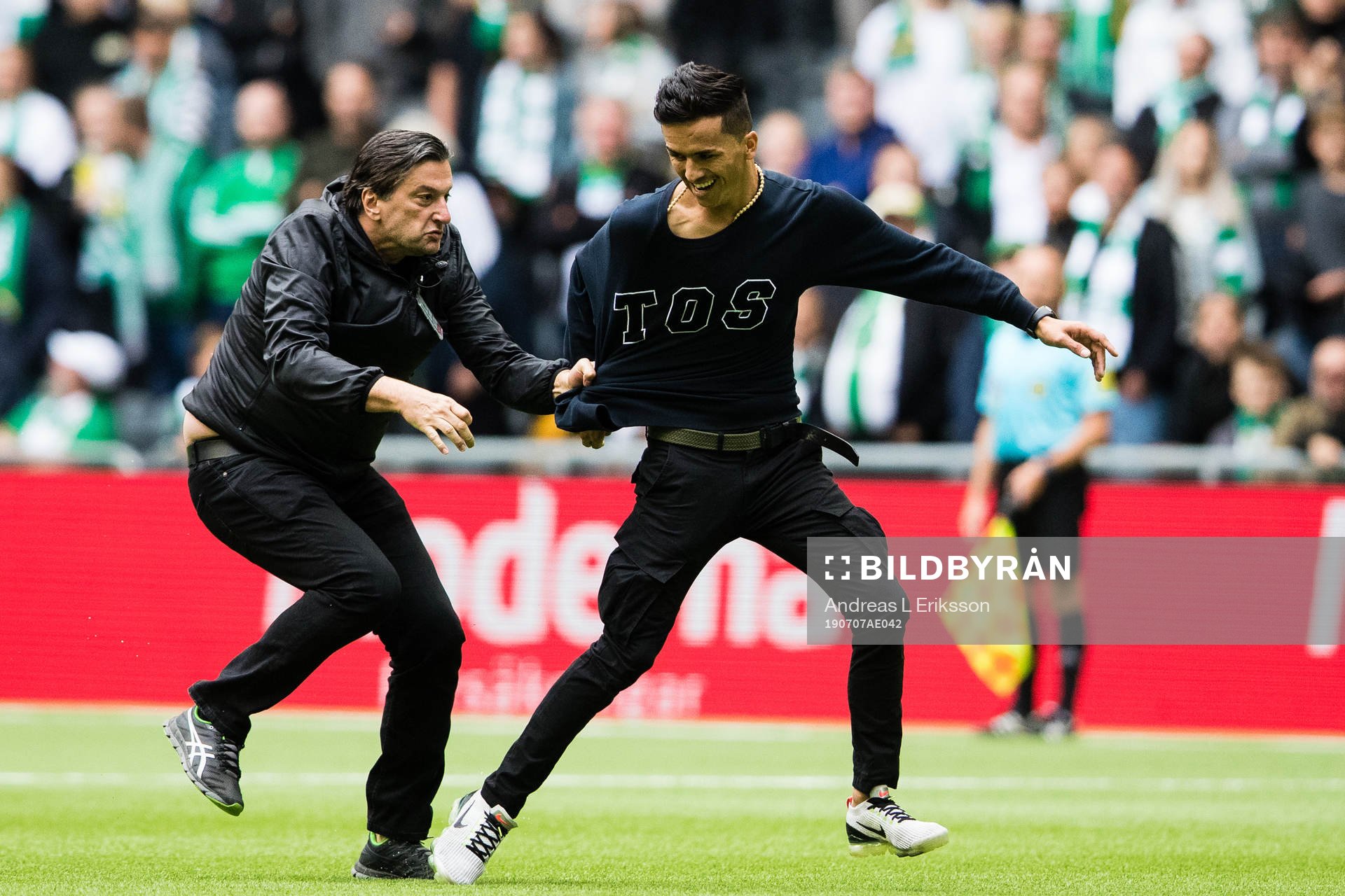 Säkerhetspersonal från Hammarby stoppar en åskådare som