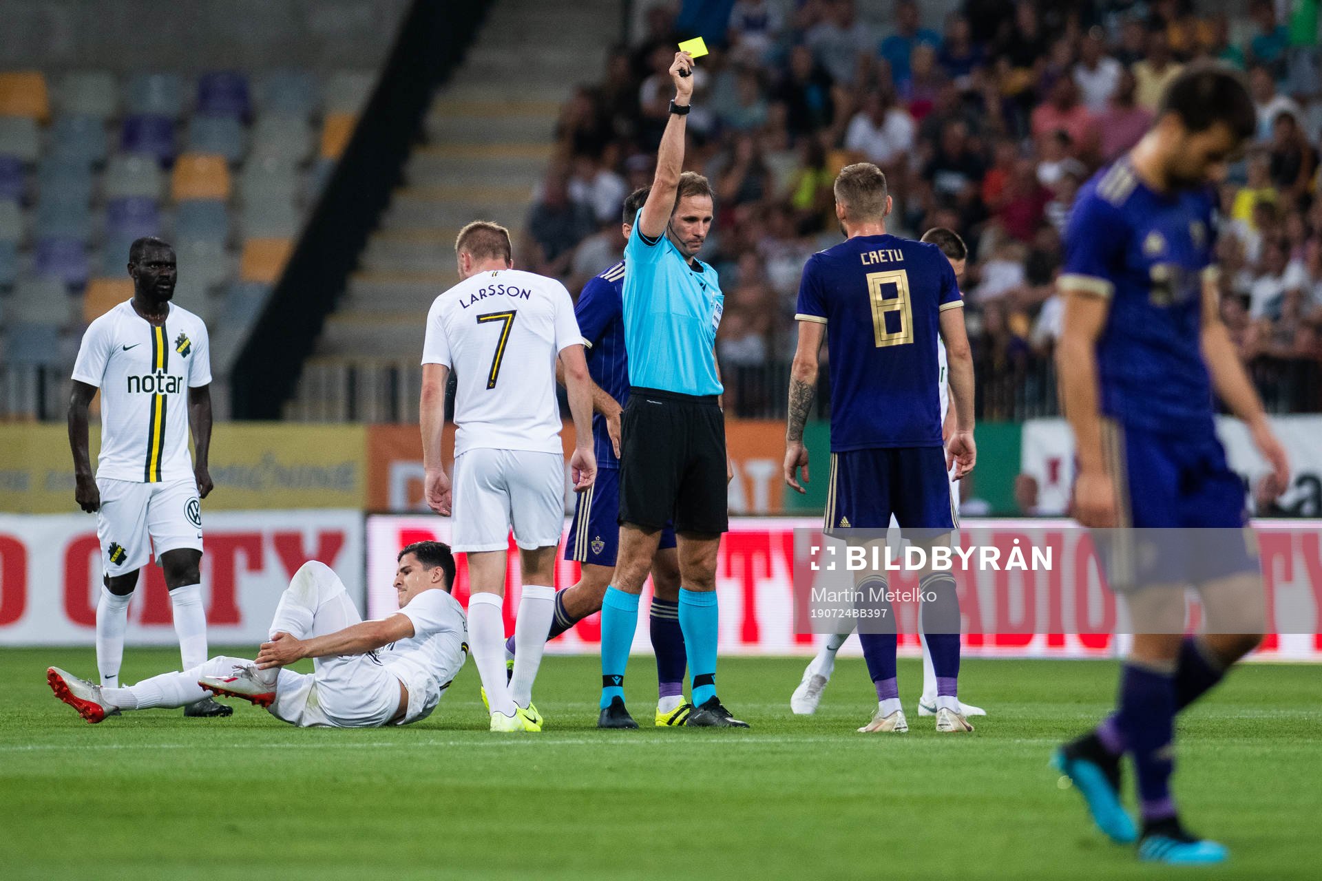 Referee Sascha Stegemann gives a yellow card to Alexandru