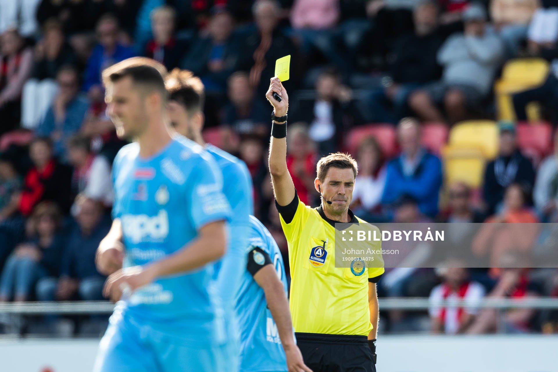 huvuddomare Magnus Lindgren visar ett gult kort för AFC