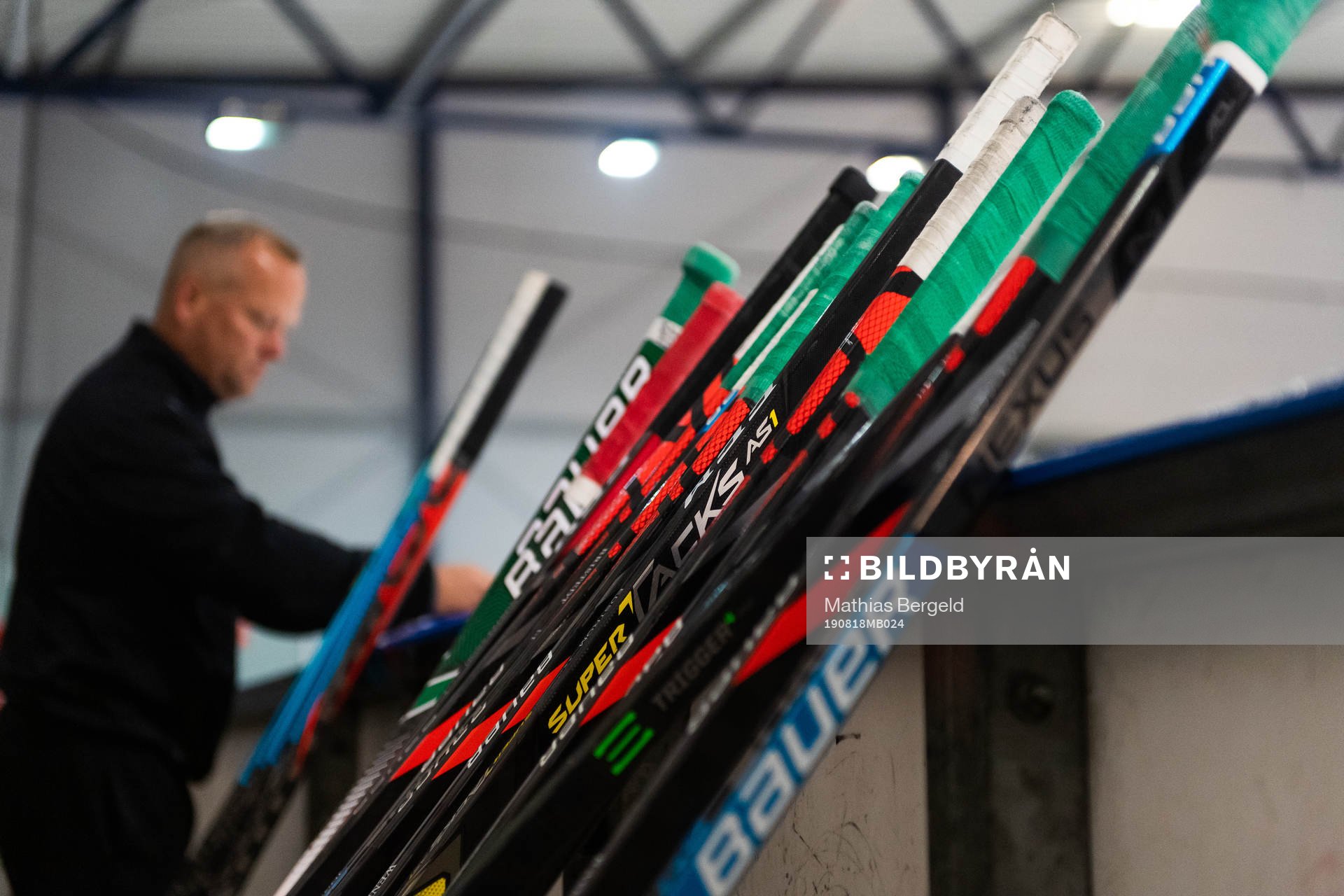 Ishockeyklubbor står lutade mot sargen på en träning med