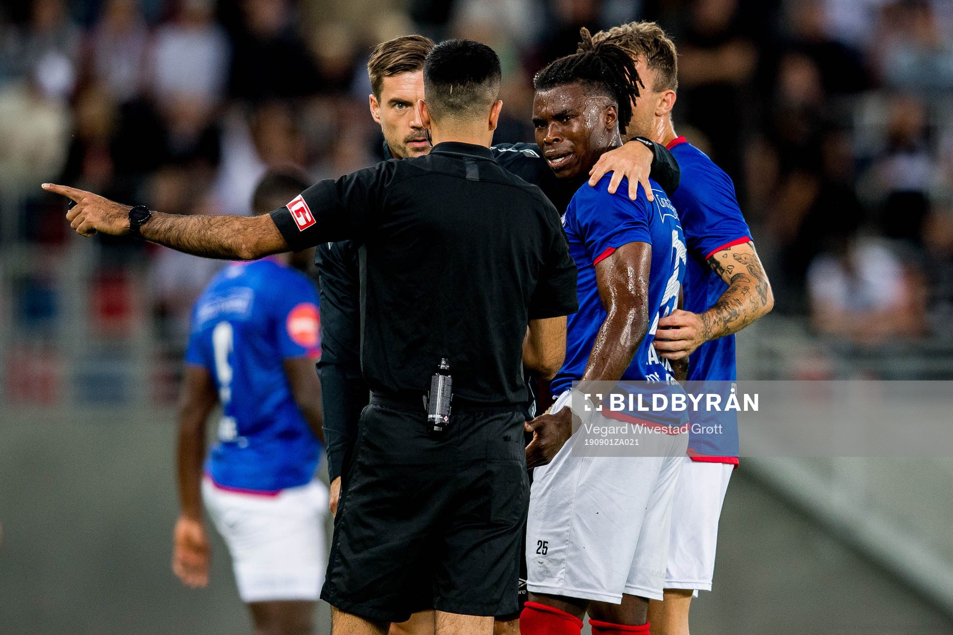 Sam Adekugbe of Vålerenga talks to Rohit Saggi, referee