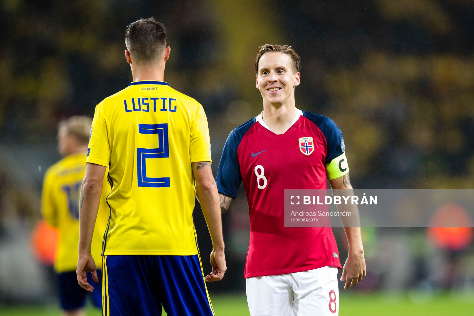 Stefan Johansen of Norway smiles with Mikael Lustig of