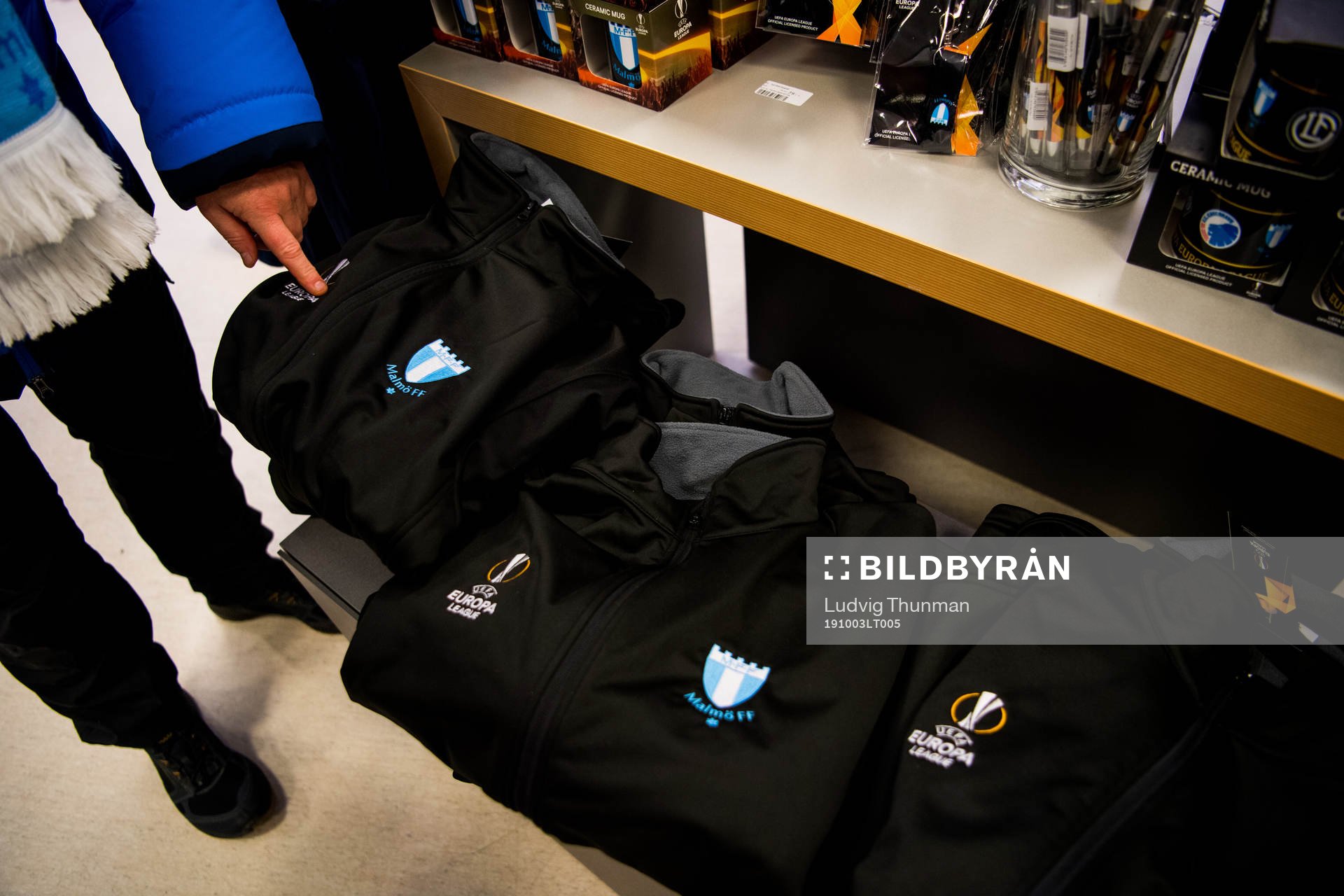 Visitors look at sweatshirts with the logo of Malmö FF and