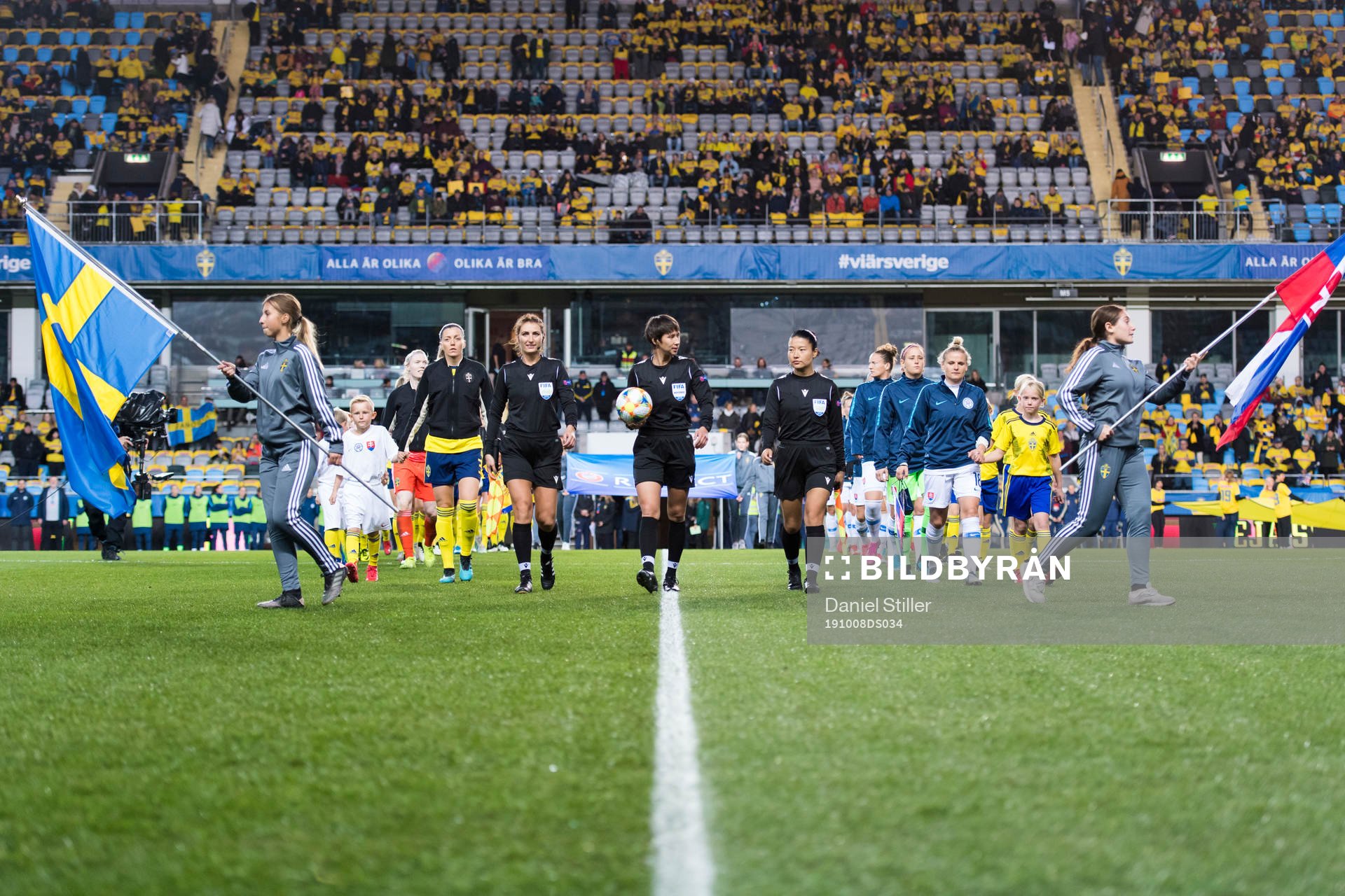 Referee Elvira Nurmustafina walks into the pitch together