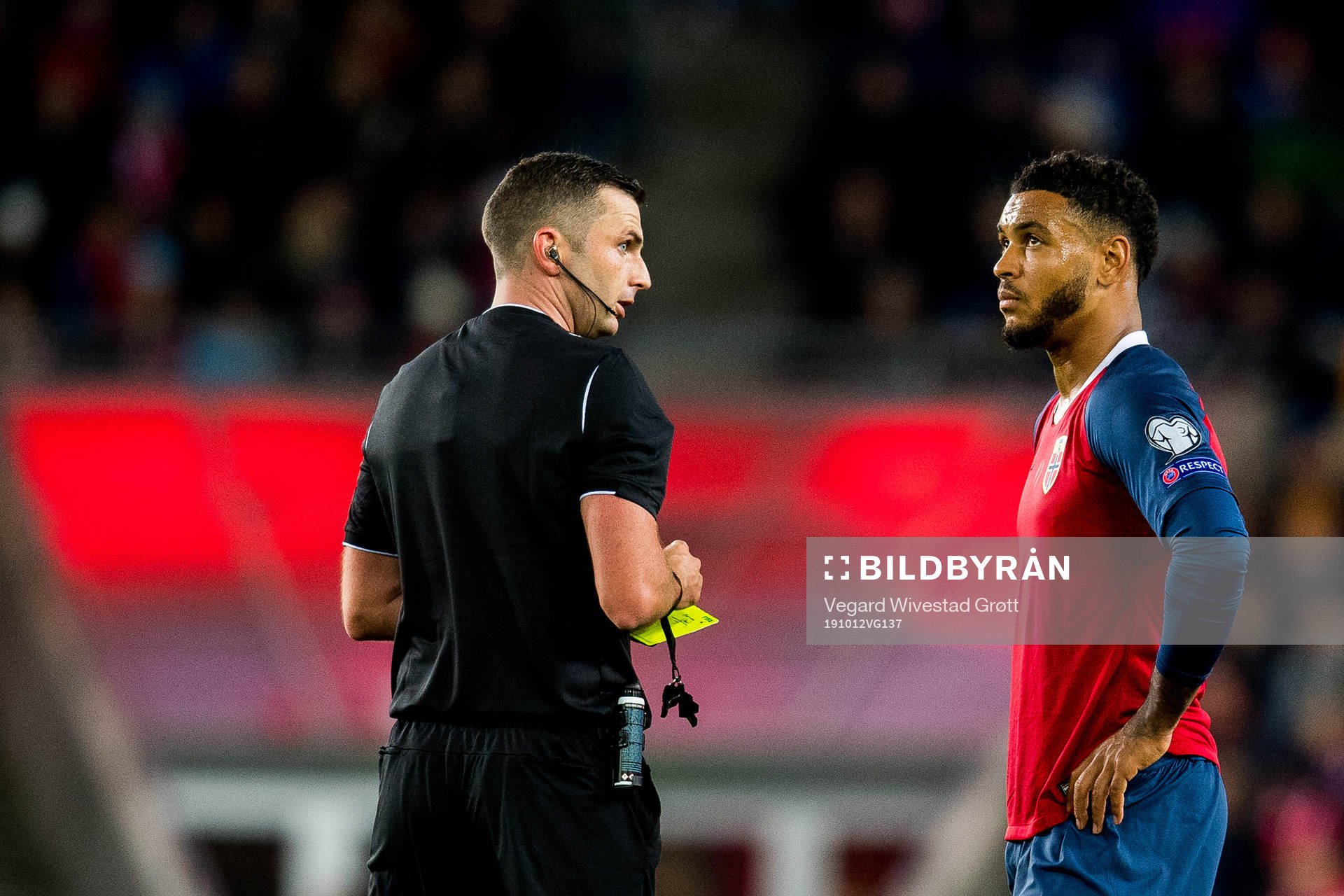 Referee Michael Oliver gives a yellow card to Joshua King