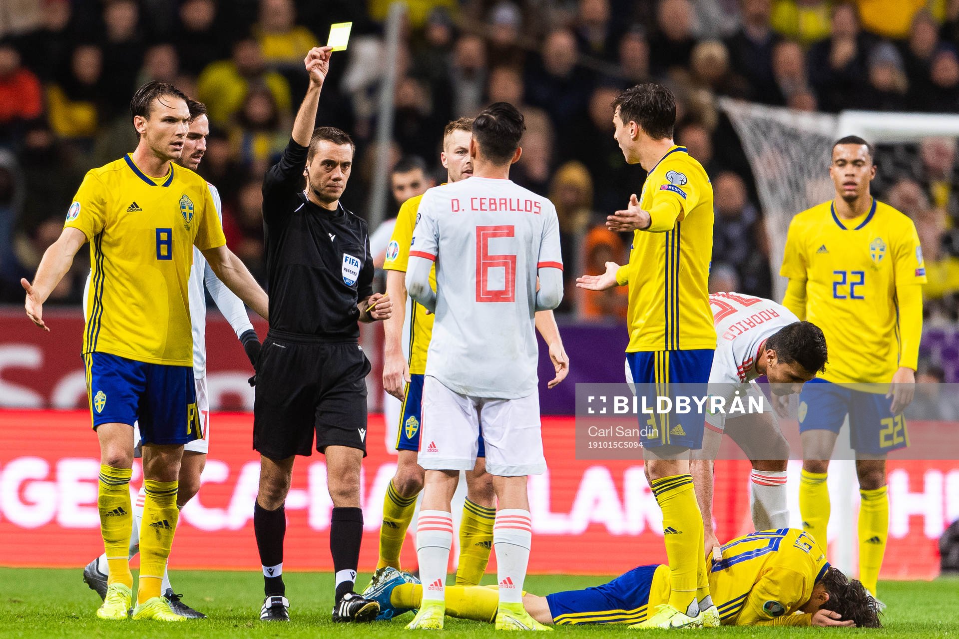 Dani Ceballos of Spain receives a yellow card from referee
