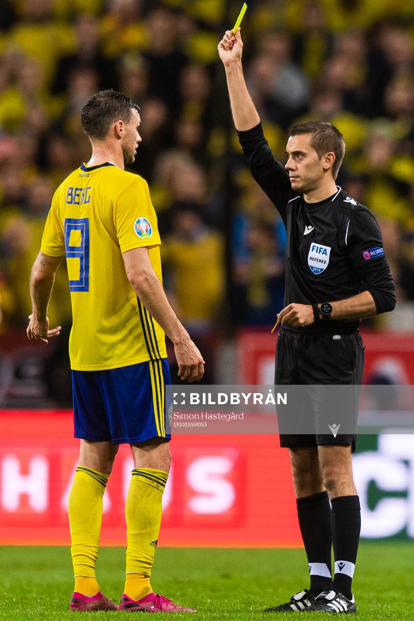 Marcus Berg of Sweden recieves a yellow card from referee
