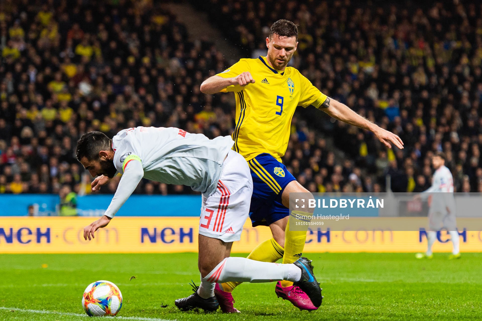 Raul Albiol of Spain and Marcus Berg of Sweden compete for