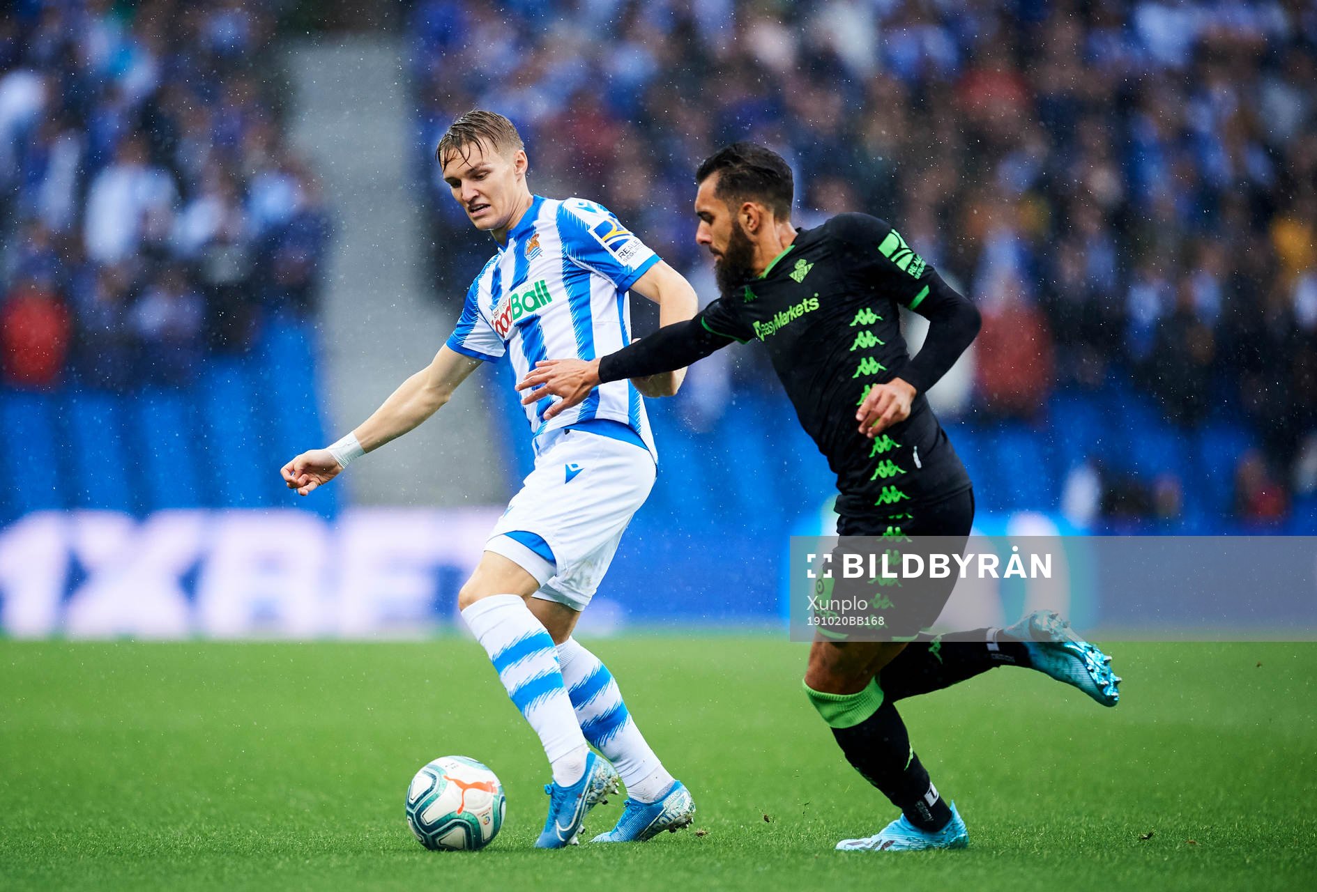 Martin Odegaard of Real Sociedad battles for the ball with