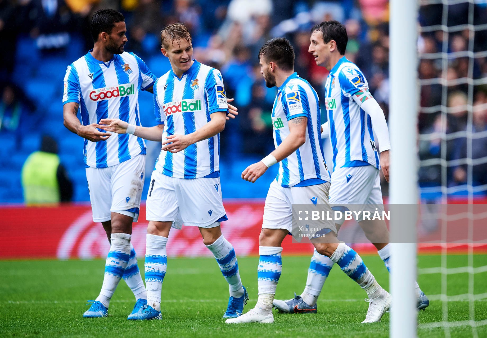 Cristian Portugues of Real Sociedad celebrates with his teammates Martin Odegaard of Real Sociedad after scoring his team's second goal during the La Liga match between Real Sociedad and Real Betis Balompie on October 20, 2019 in San Sebastian, Spain. 