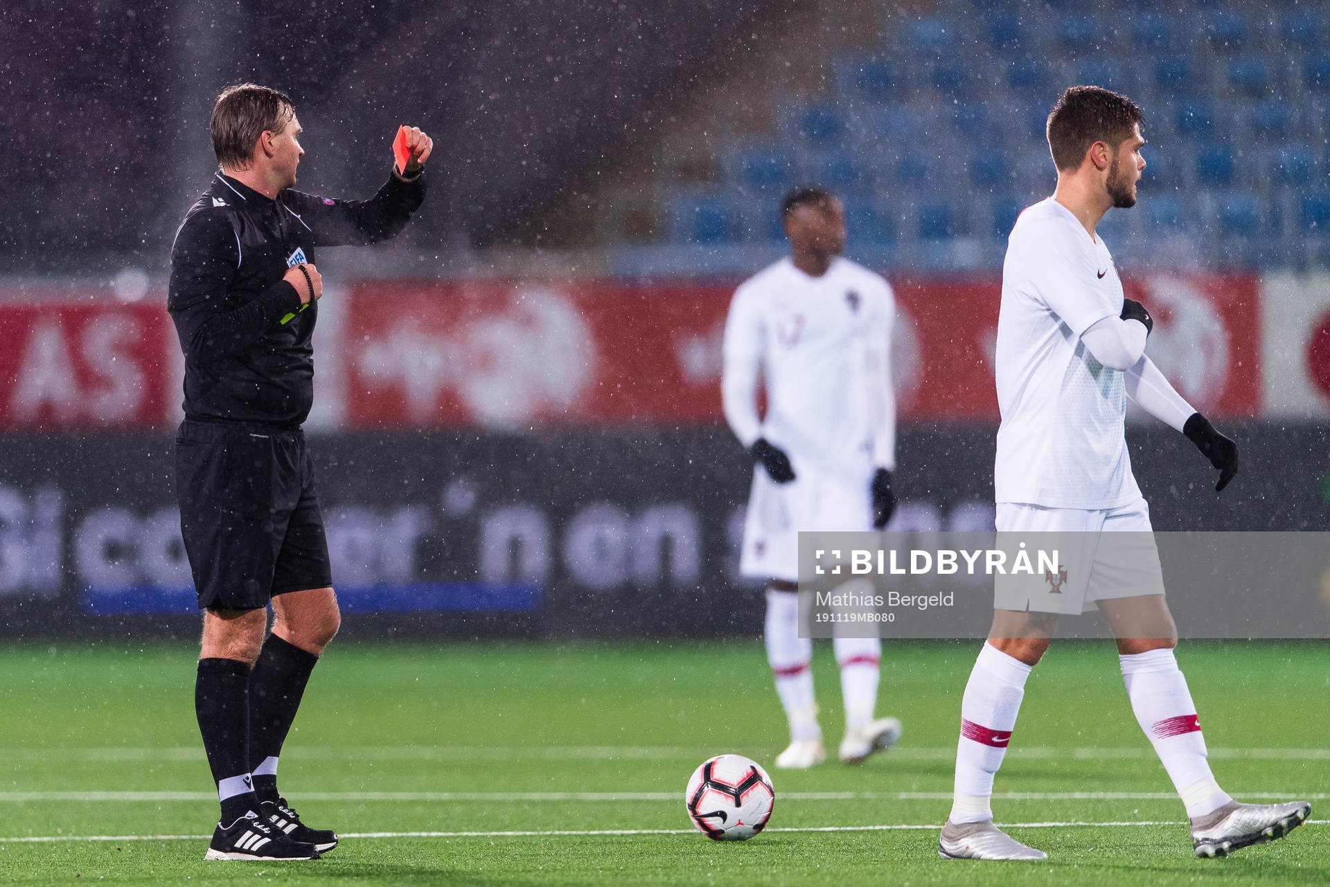 Referee Segei Lapochkin gives a red card to Diogo Queiros