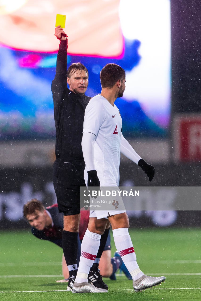 Referee Segei Lapochkin gives a yellow card to Diogo