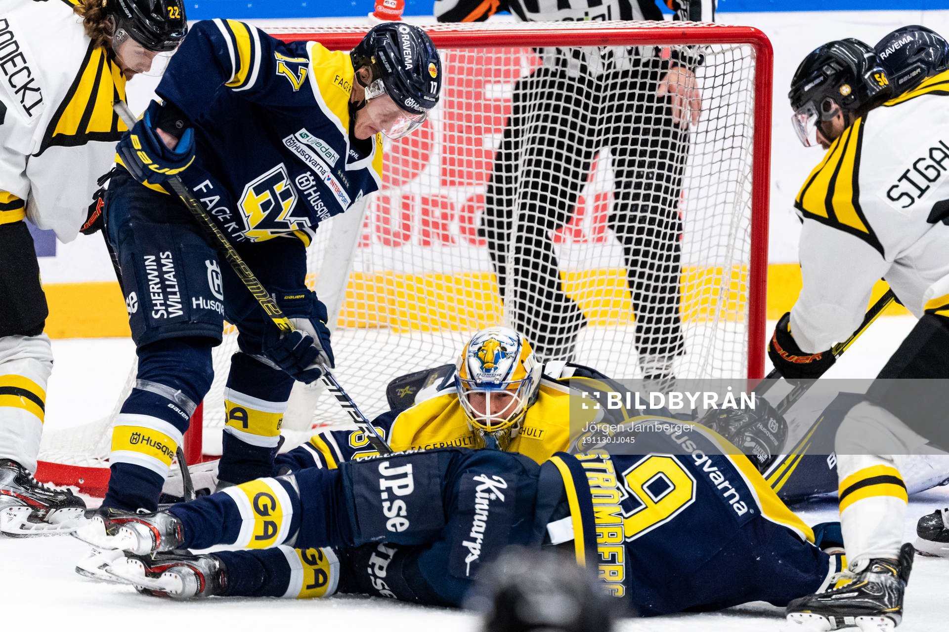 s målvakt Hugo Alnefelt täcker puck med Emil Johansson