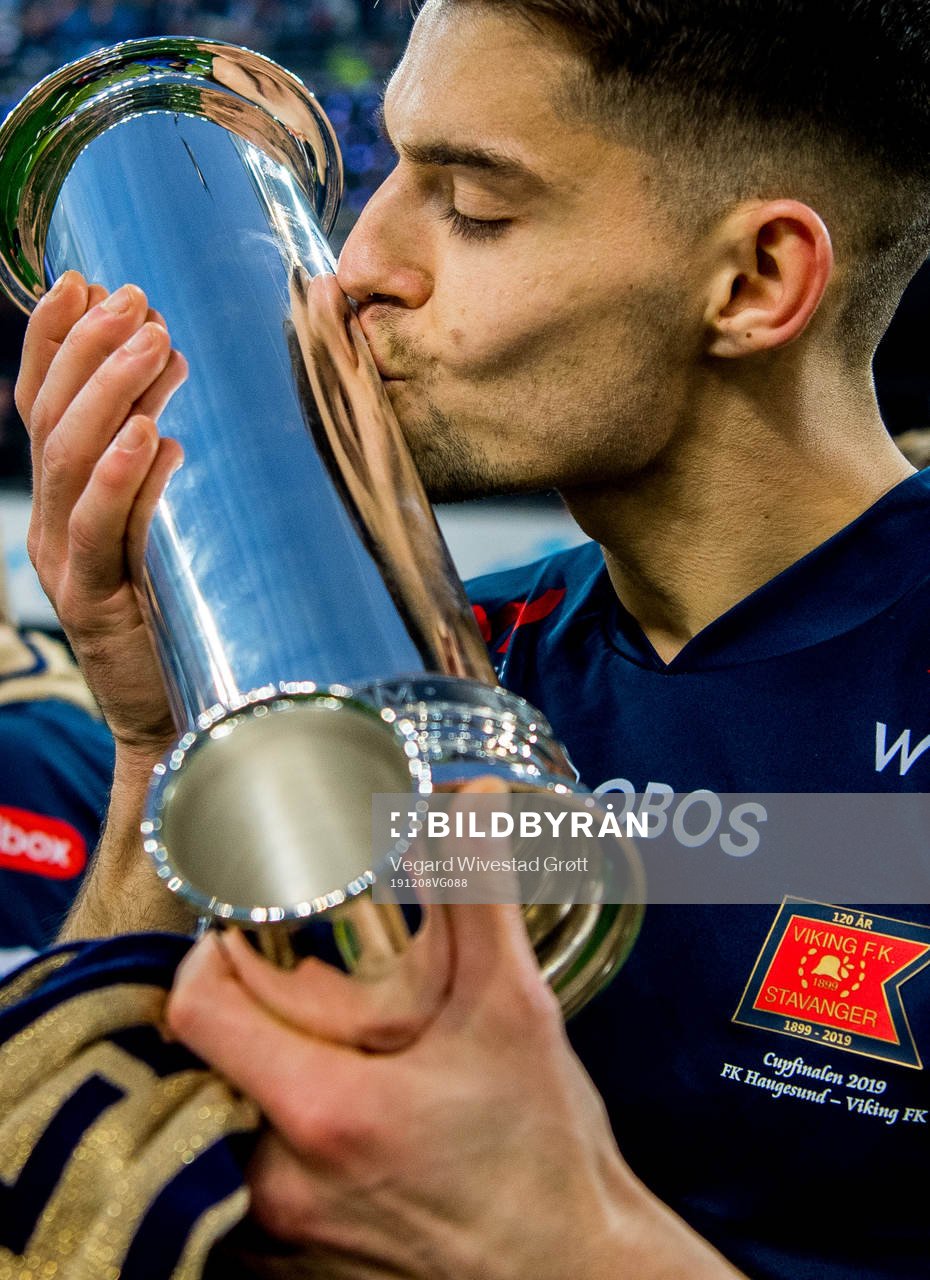 Ylldren Ibrahimaj of Viking kisses the trophy