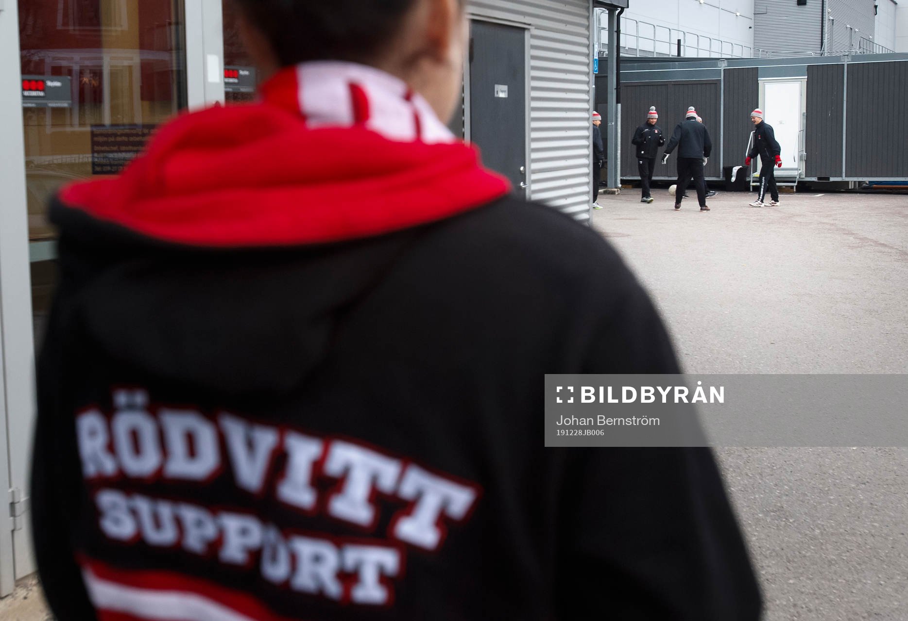 En Örebro supporter tittar på Örebrospelarna som värmer