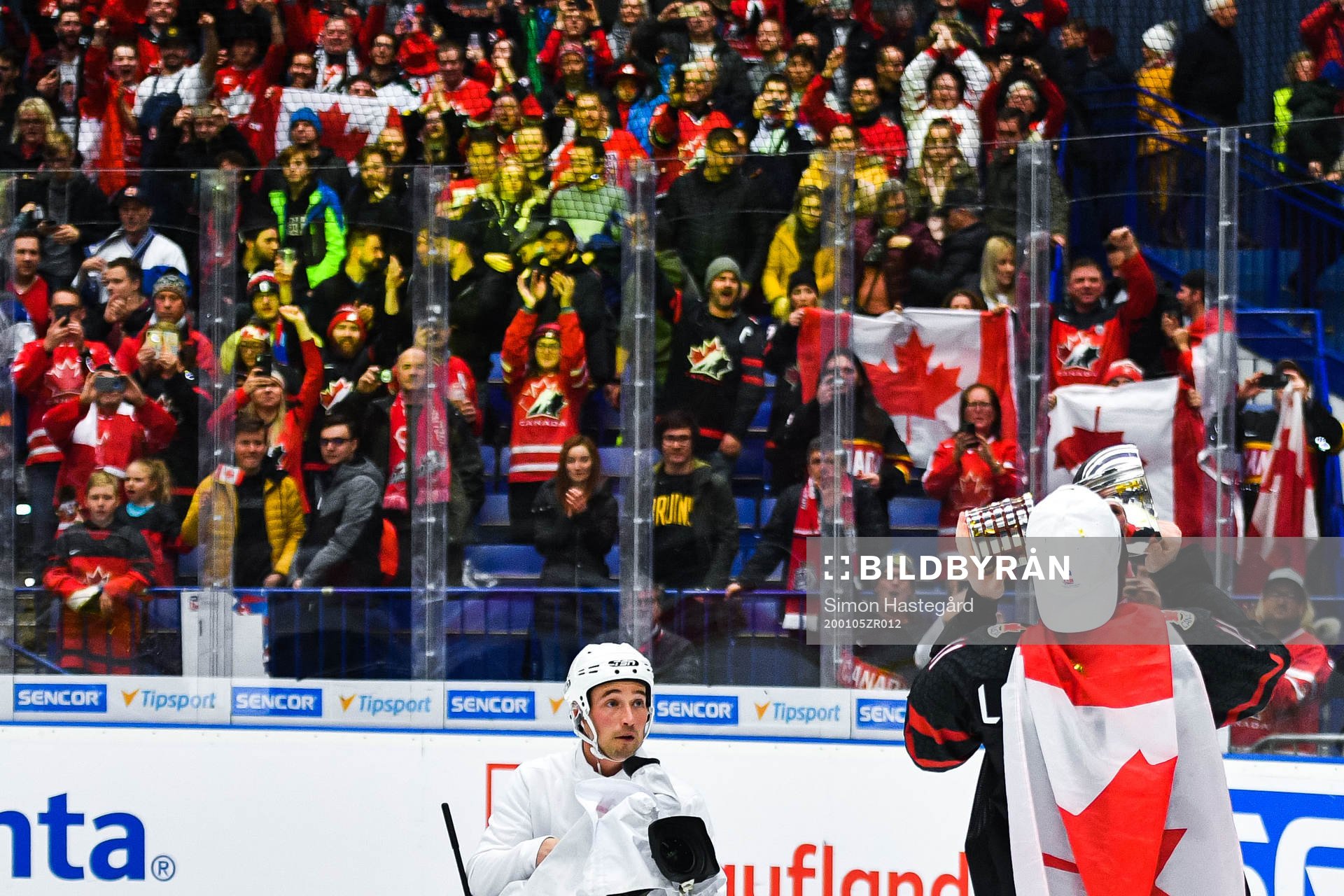 Alexis Lafreniere of Canada celebrate with the trophy and a