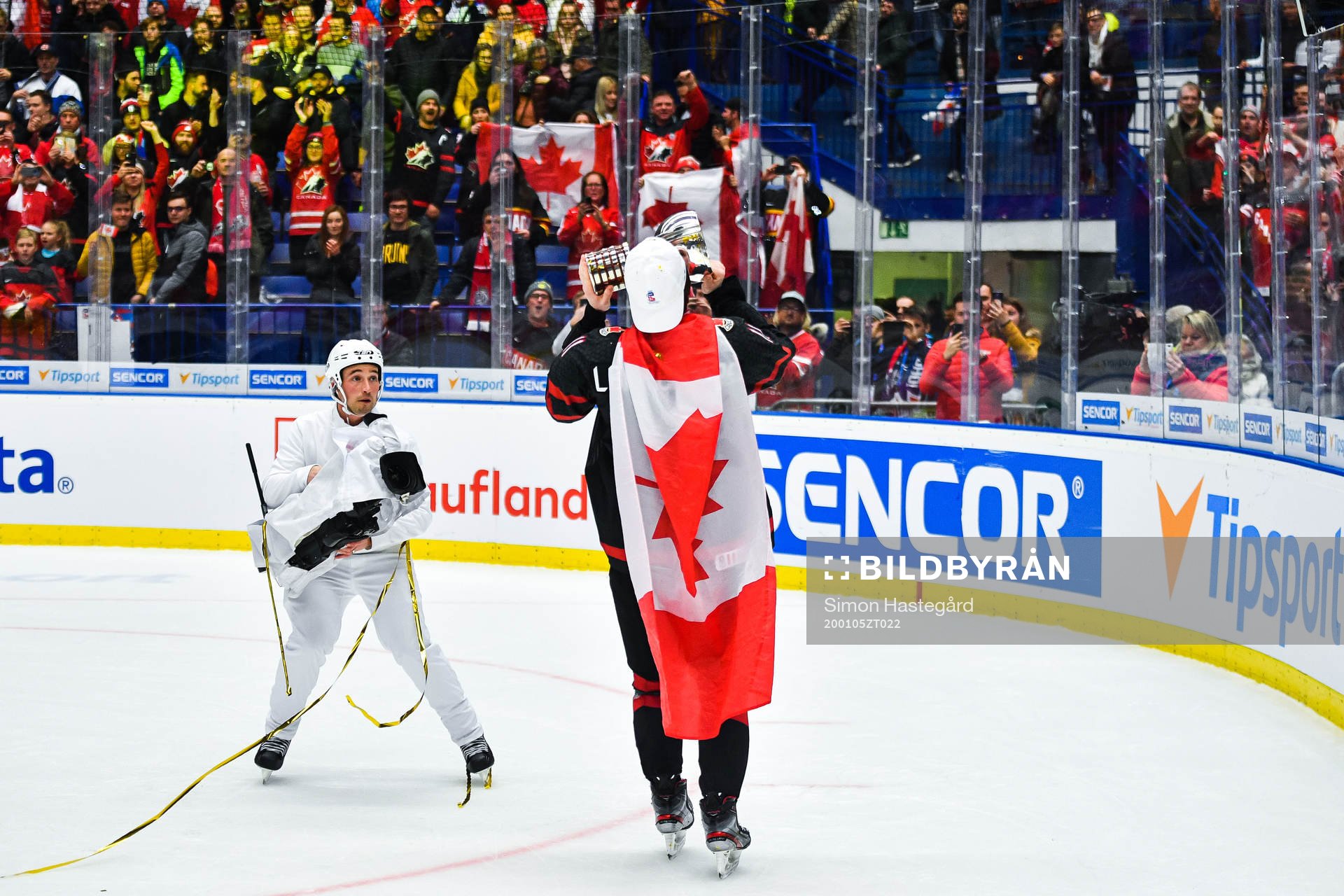 Alexis Lafreniere of Canada celebrate with the trophy and a