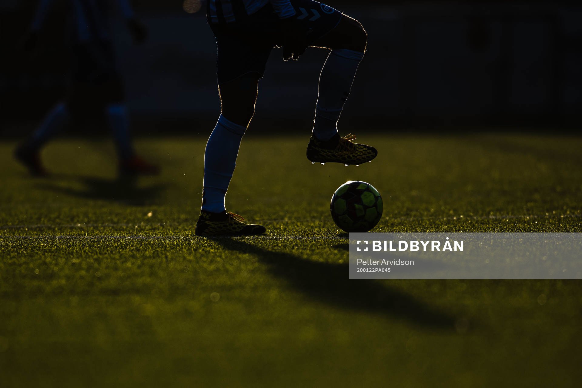 Siluett av en fotbollsspelare med boll