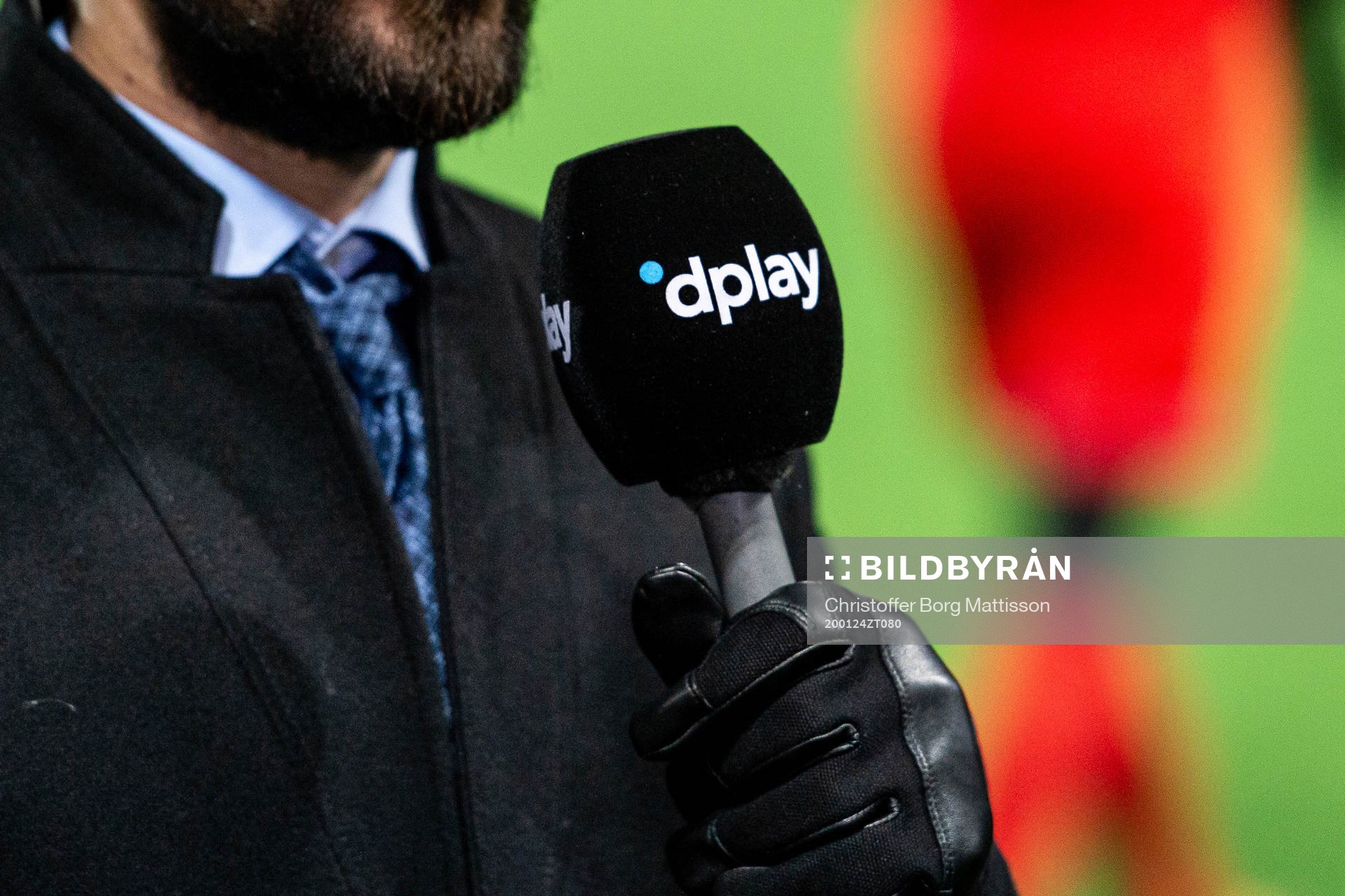 En reporter håller i en mikrofon med dplays logo på