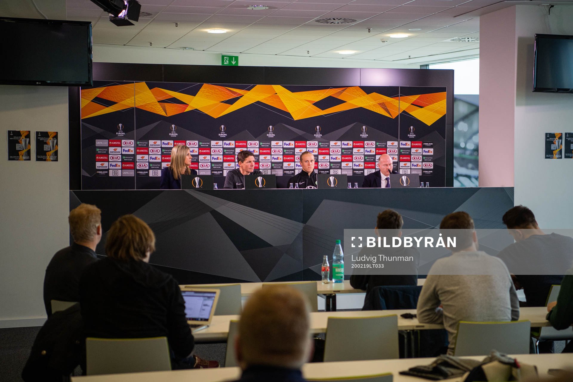 Members of the media listen to a press conference with