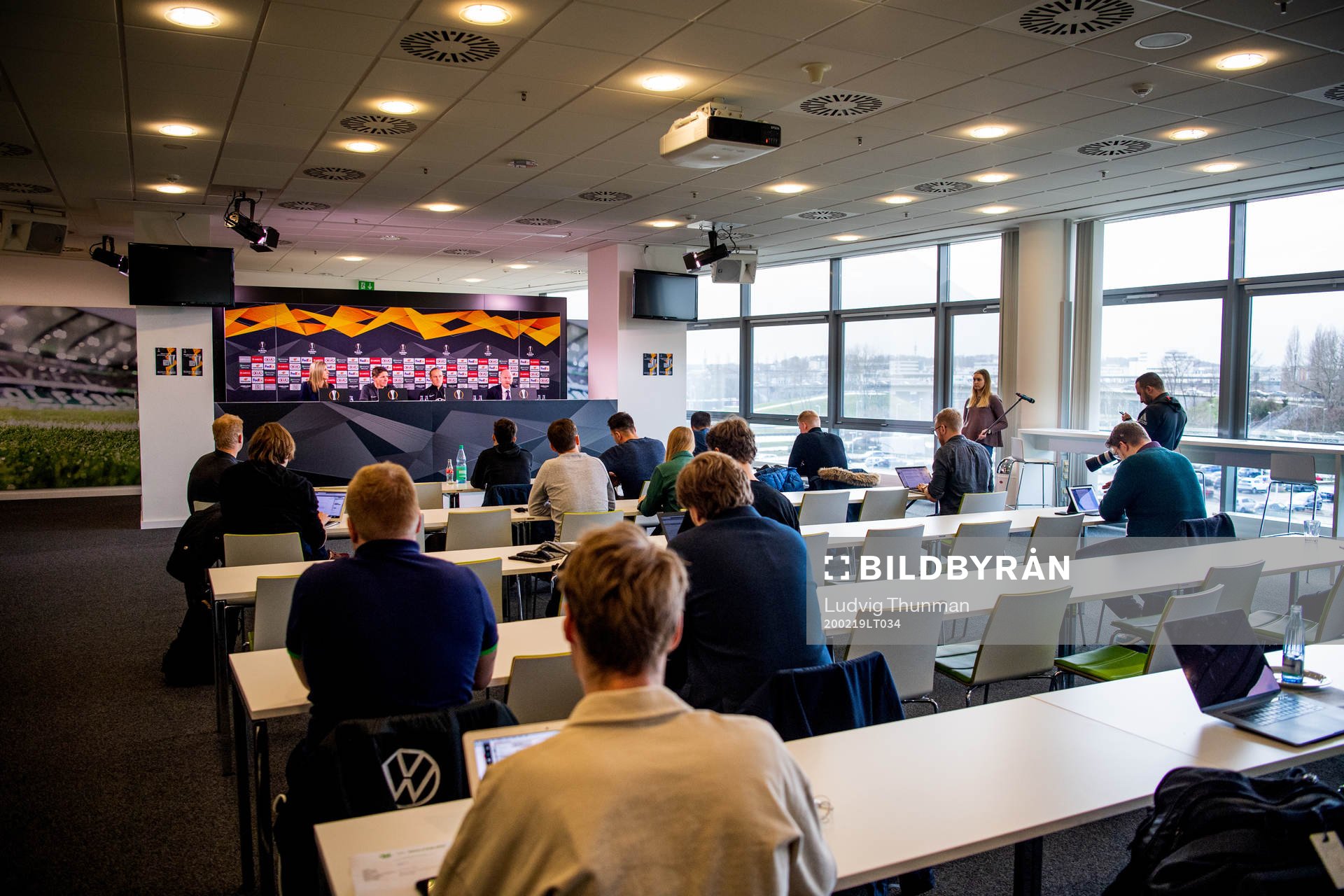 Members of the media listen to a press conference with