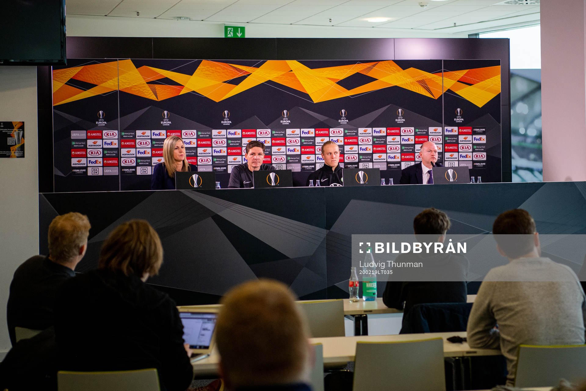 Members of the media listen to a press conference with