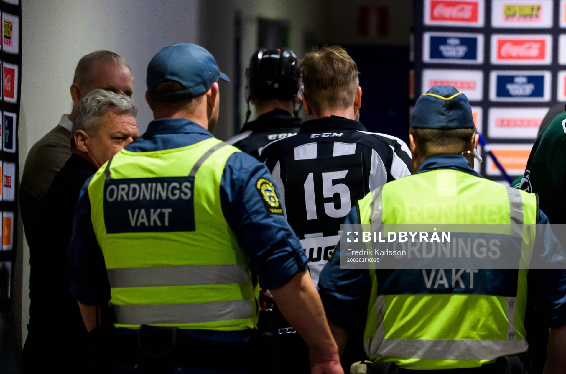 Domare Patrik Sjöberg blir eskorterad av vakter in till